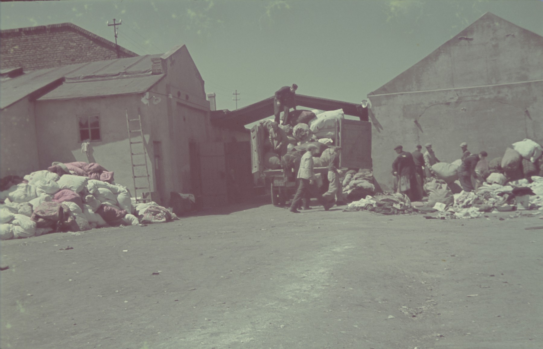 Jews load bales of confiscated goods onto trucks in the Pabianice labor camp/storage facility.

Original German caption: "Pabianice, Verladung" (loading), #34.
