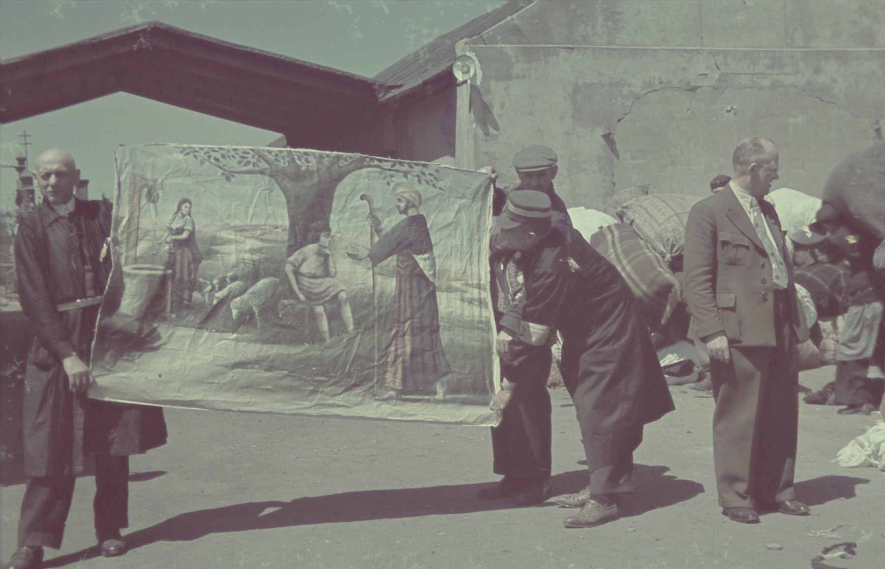 Jewish laborers display a confiscated work of art that was brought to the Pabianice labor camp/storage facility.

Original German caption: "Pabianice, Juedische Kunst" (Jewish art), #33.