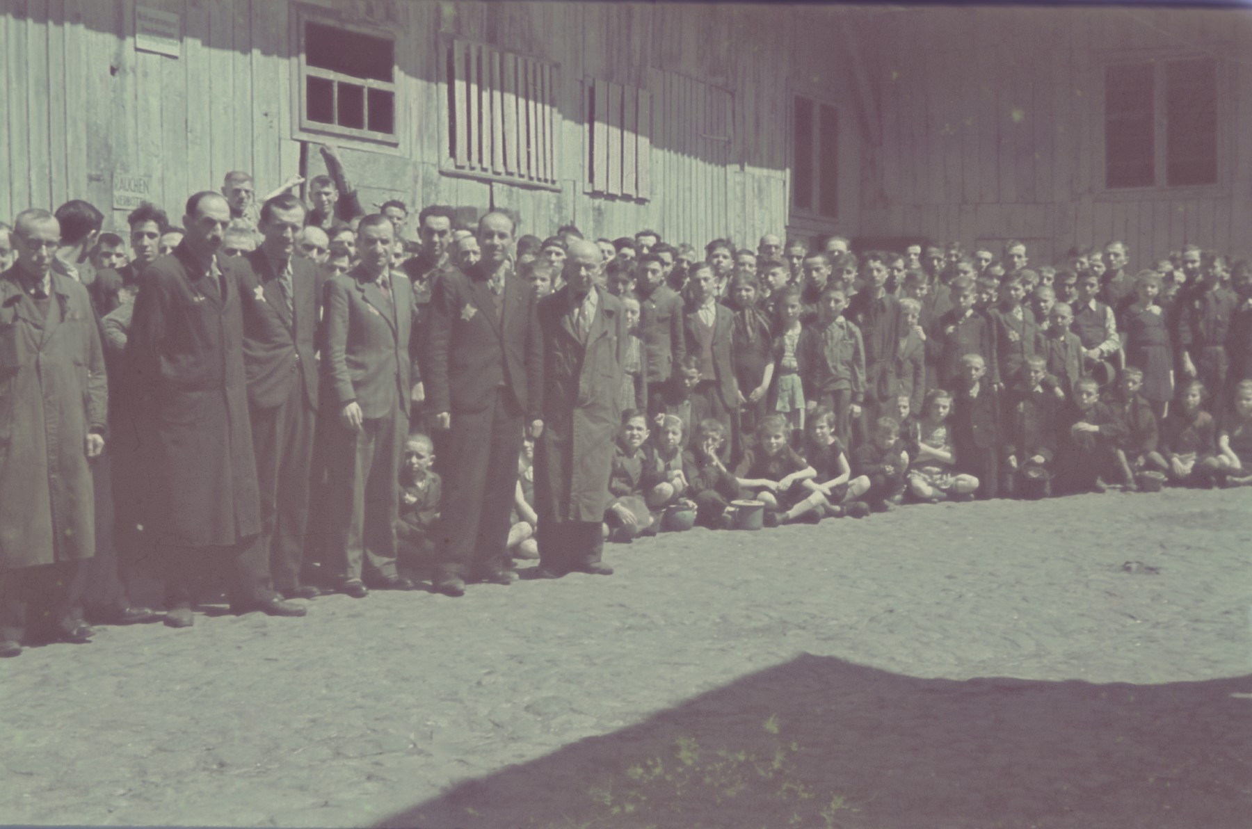 Group portrait of personnel, including many children, of the furniture factory in the Lodz ghetto.

Original German caption: "Getto Litzmannschaft, Gefolgschaft der  Moebelfabrik" (personnel of the furniture factory), #177.