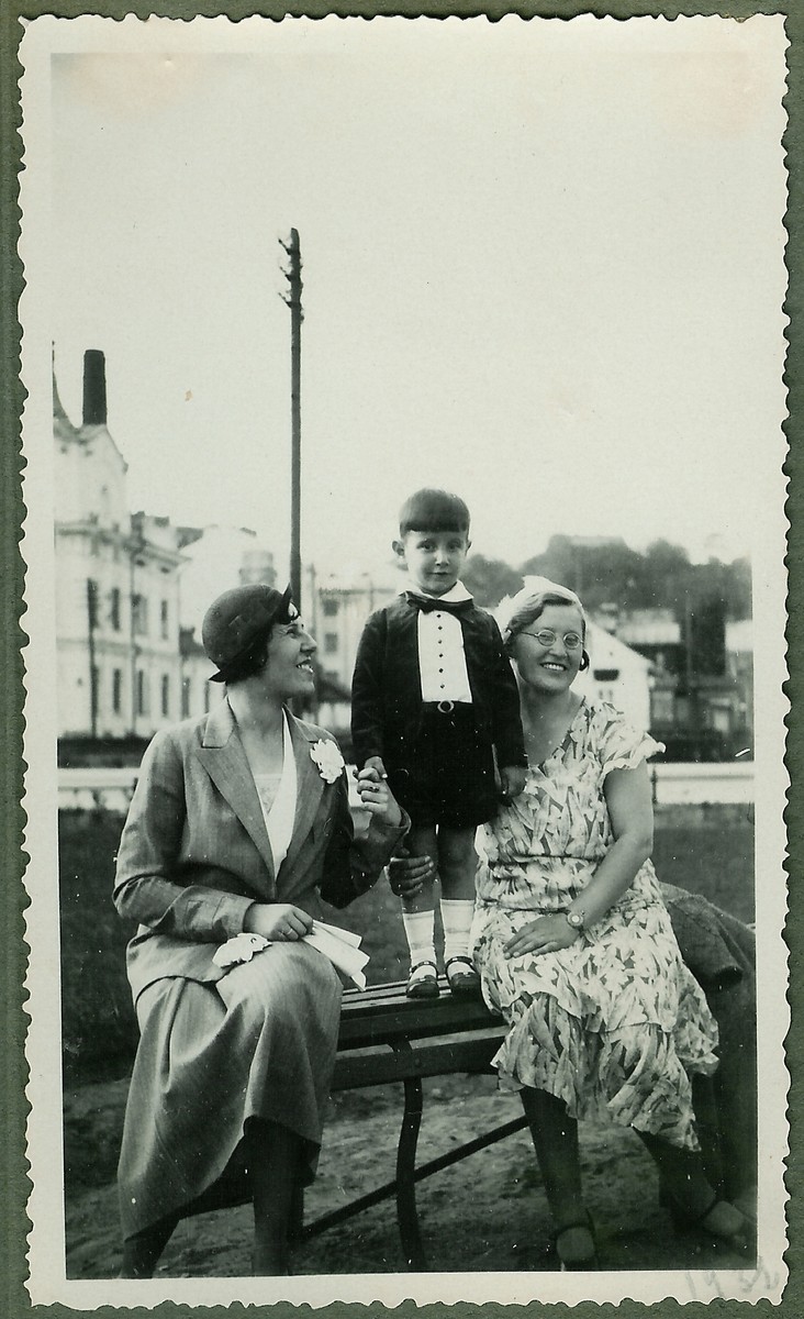 A young Lithuanian Jewish boy dressed in formal clothes poses on a park bench between his mother and nanny, near his home on Vienybes Square in Kaunas.

Pictured are Eugenia and Dmitri Kopelman, and Nadezhda Jakubovskaja.