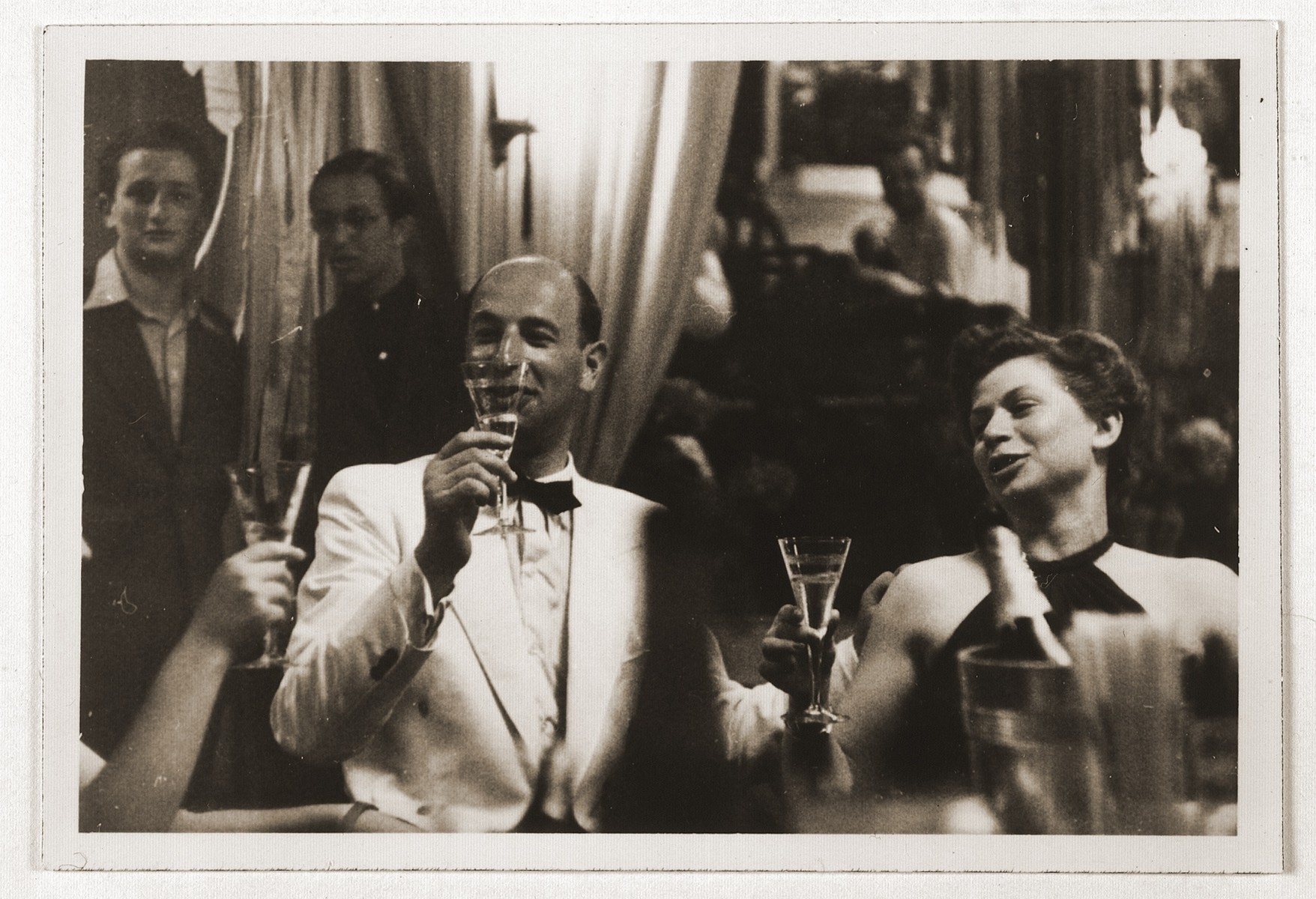 A couple in evening dress raise their glasses in a toast, aboard the MS St. Louis.

Pictured are Kurt  Strauss and Kathe Jellinek.