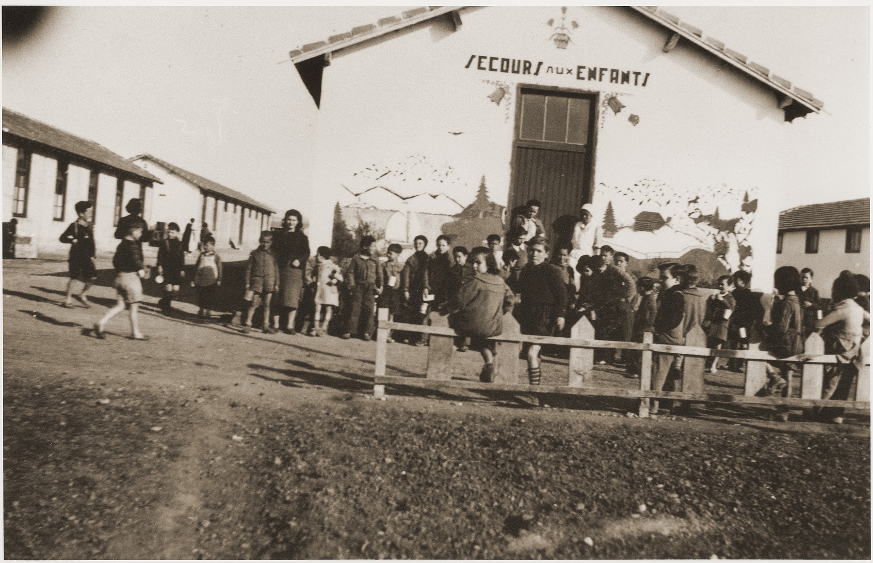 Children wait outside the Secours Suisse barracks for a meal to be served.