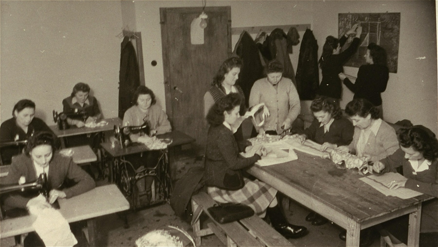 Women practice using sewing machines in an ORT sponsored sewing class in the camp.

Pictured standing at table (on the right)  is Chana Leutzner.
