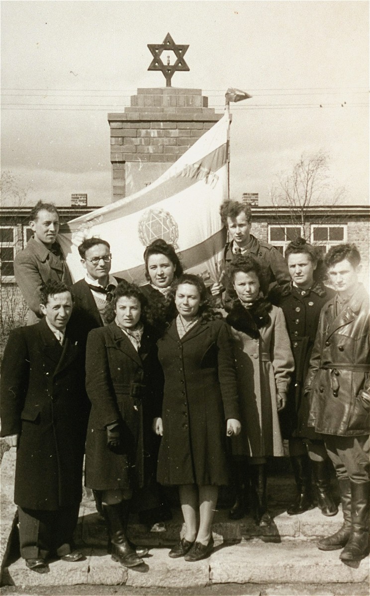 Zionist youth stand with a Zionist flag in front of a memorial in the Zeilsheim displaced persons' camp.

Pictured here in the back row, second from the left is Sheyne-Bela Berk (Propis), and Luba Autoputsky, in the front row, first on the right.  Lula is first cousin of Jona Wigardsky.