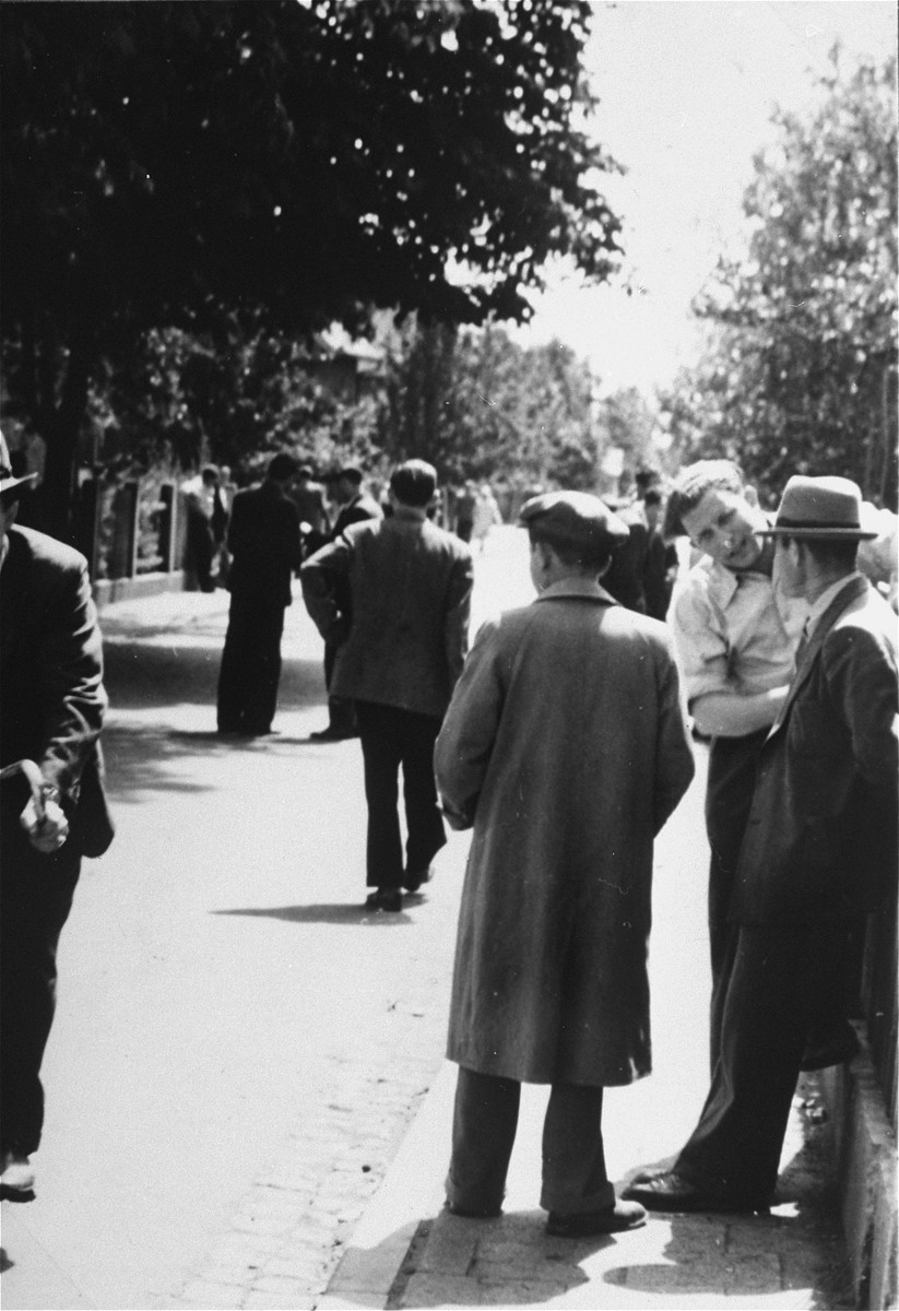 Jewish men walk down a street in the Zeilsheim displaced persons' camp.