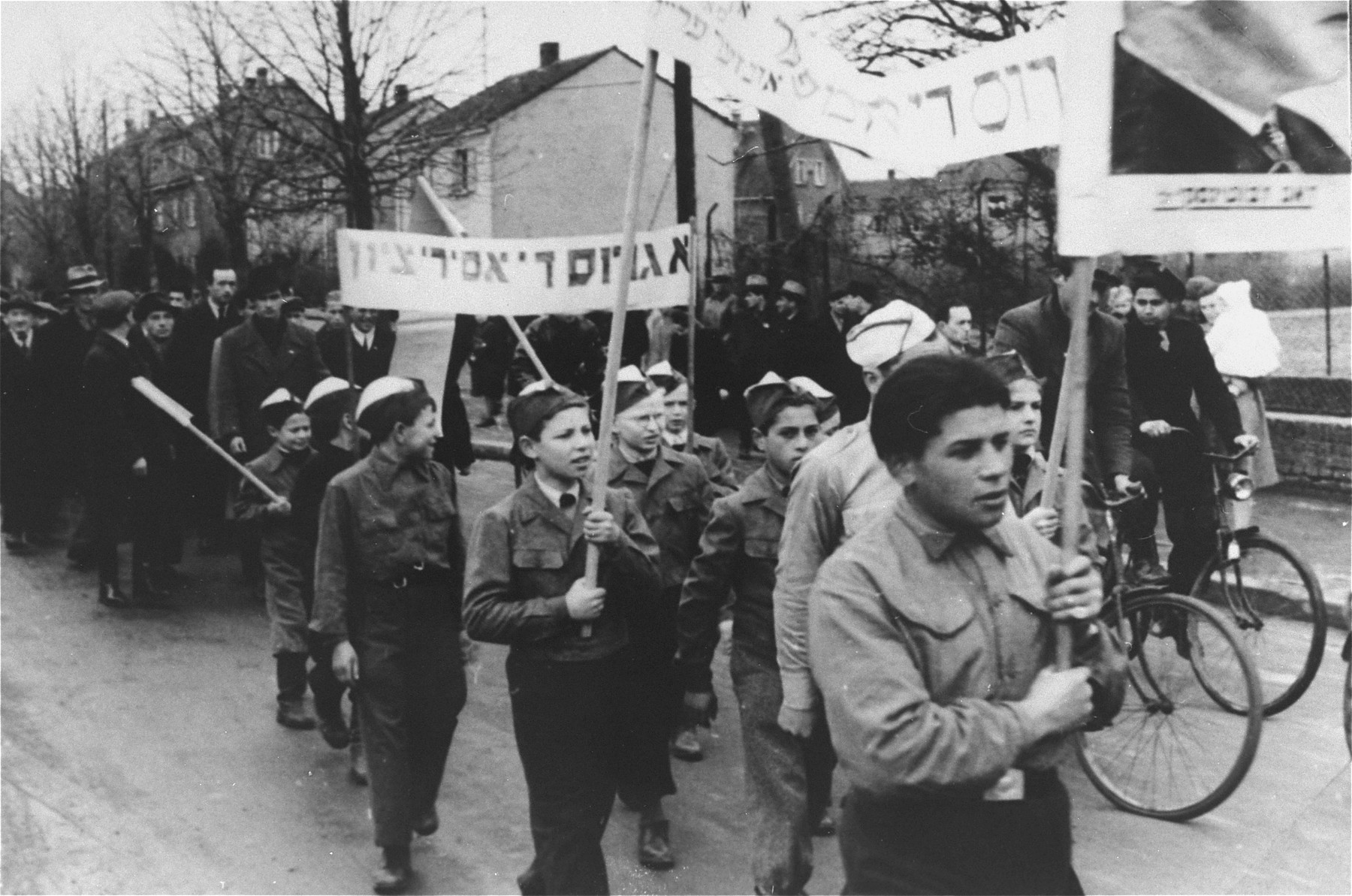 Children in the Zeilsheim displaced persons' camp carrying banners march in a demonstration for free immigration to Palestine.