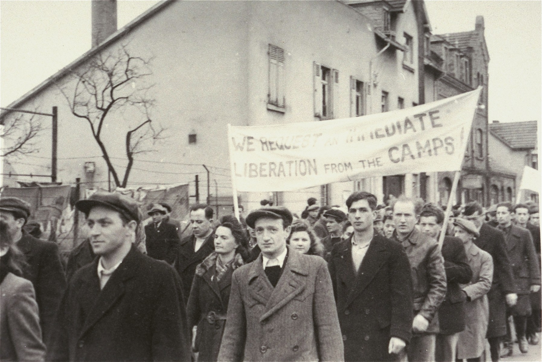 Men and women in the Zeilsheim displaced persons' camp carrying banners march in a demonstration for free immigration to Palestine.