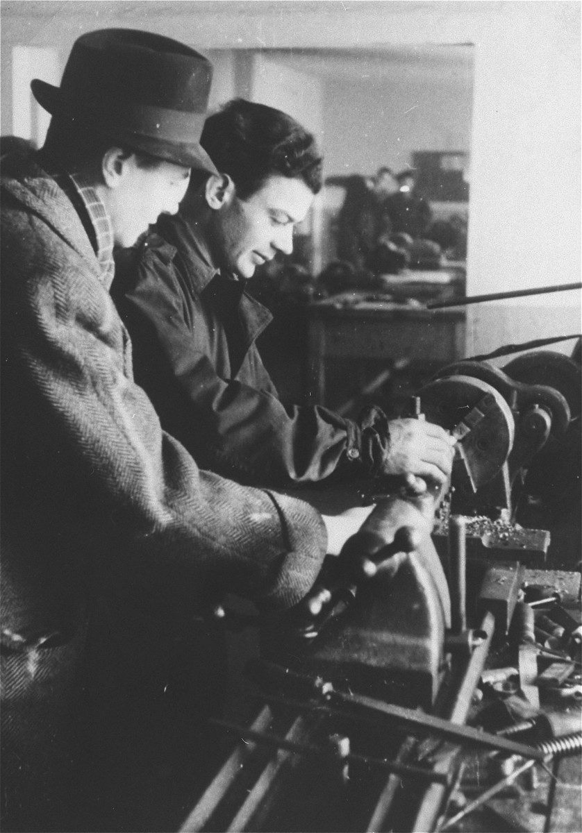 Two men work with a large machine in an ORT vocational school in the Zeilsheim displaced persons' camp.