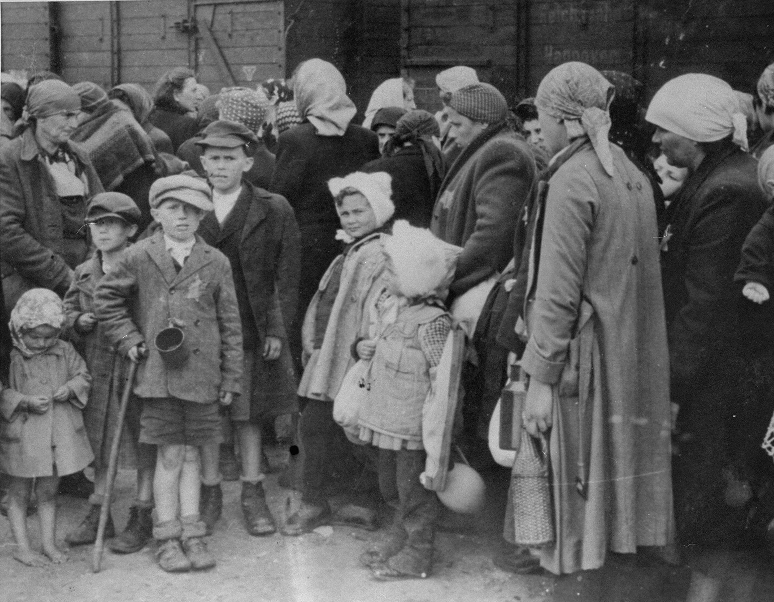 Jewish women and children from Subcarpathian Rus await selection on the ramp at Auschwitz-Birkenau.

Lili Jacob's has identified aunt Tauba with her four children.  The woman in the center with the two girls wearing rabbit fur hats have been identified as either Bozsi Iskovics Engel (b. 1904) from Beregszasz with her two daughters Agota Engel (b. 1933) and Judith Engel (b. 1936) or Breine Slomovics with her two daughters.