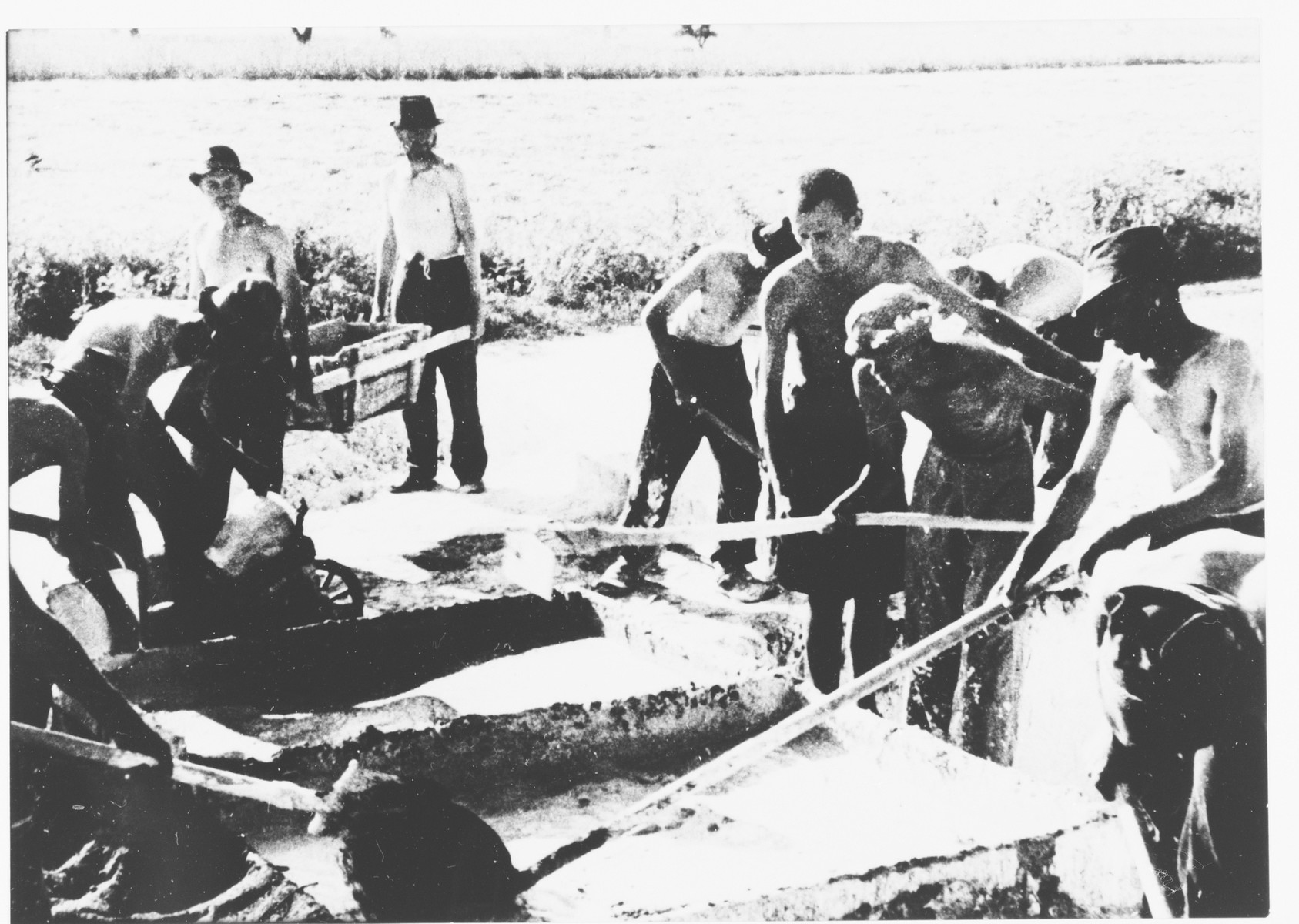 Prisoners at forced labor in the Jasenovac III concentration camp brickyard mixing lime in large troughs.

The photo was displayed in the exhibit, "One Year of Work in Transit Camps," mounted at the Zagreb fair grounds in the fall of 1942.