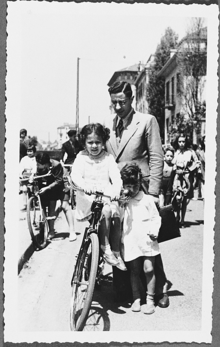 Rabbi Nathan Cassuto poses with his two older children, Susanna and David, next to a bicycle on a street in Milan.