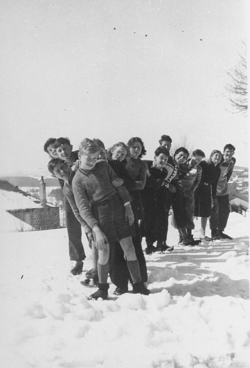 Jewish youth who are living at the La Guespy refugee home in Le Chambon, pose in the snow.

This is one photo from an album presented to Elizabeth Kaufmann prior to her departure from the La Guespy refugee home in Le Chambon-sur-Lignon.  

Founded in 1941 by the Secours Suisse aux enfants and run by Juliette Usach, the La Guespy children's home provided shelter to a number of Jewish and non-Jewish refugee children who were living in Le Chambon-sur-Lignon during the Nazi occupation.