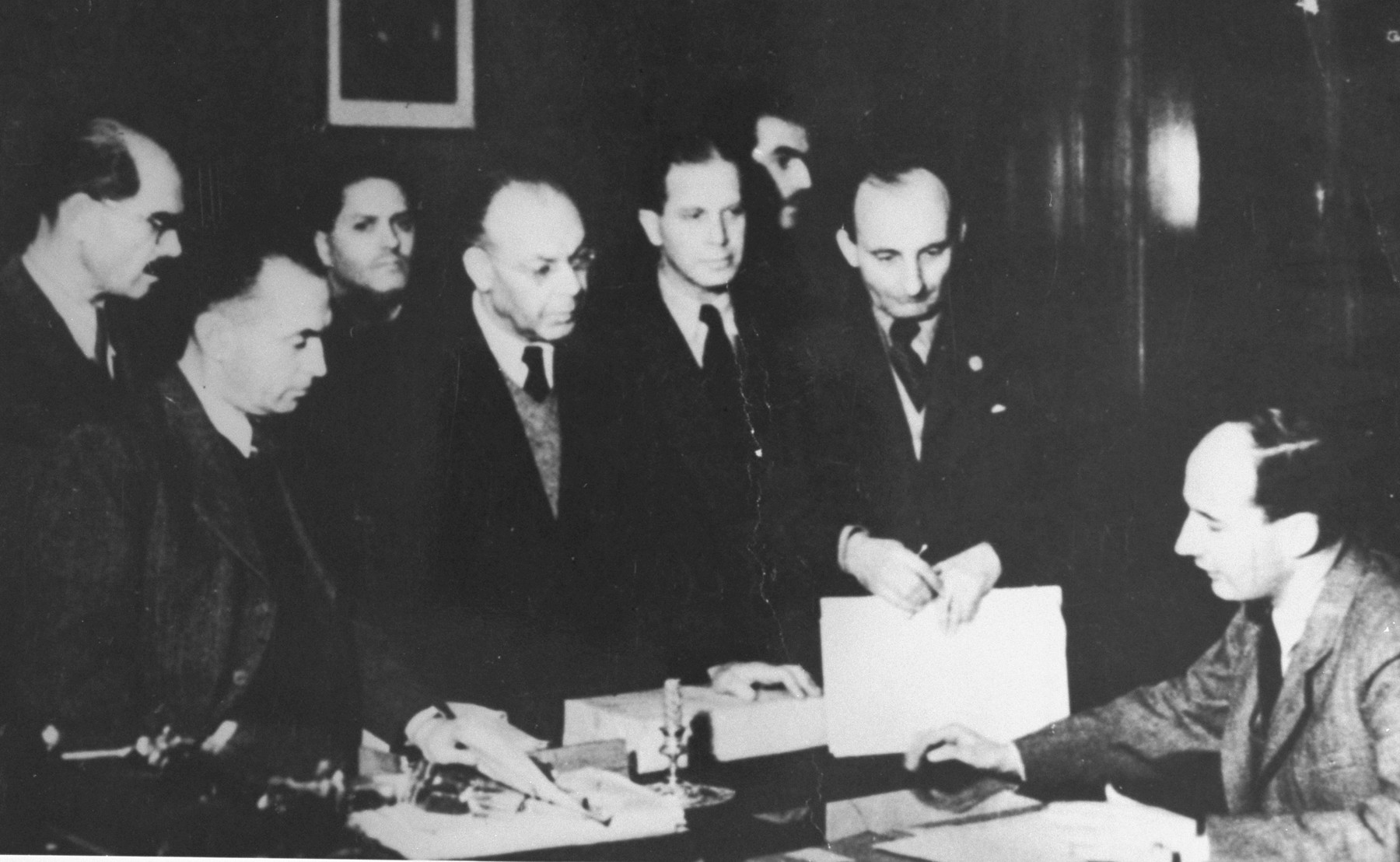 Raoul Wallenberg in his Budapest office with his Jewish co-workers in November 1944. 

Pictured from left to right are: Dannonbergt, Hugo Wohl, Klein (behind), Forgacs (with V-neck sweater), and Paul Hegedus.  Behind are Tibor Vandor and Dr. Otto Fleishmann.