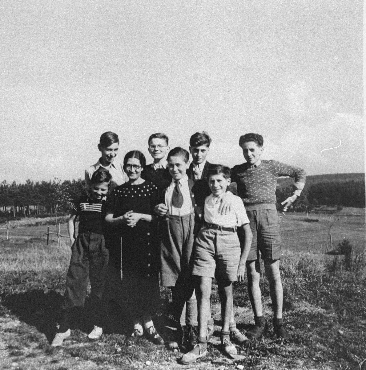 Juliette Usach poses with a group of Jewish youth who are living at the La Guespy children's home in Le Chambon-sur Lignon.

This is one photo from an album presented to Elizabeth Kaufmann prior to her departure from the La Guespy refugee home in Le Chambon-sur-Lignon.  

Founded in 1941 by the Secours Suisse aux enfants and run by Juliette Usach, the La Guespy children's home provided shelter to a number of Jewish and non-Jewish refugee children who were living in Le Chambon-sur-Lignon during the Nazi occupation.

Among those pictured are Jean Nallet (back row with glasses), Joseph Atlas (back row, third from the left), Victor Atlas (back row, right), Manfred Goldberger and Juliette Usach.
