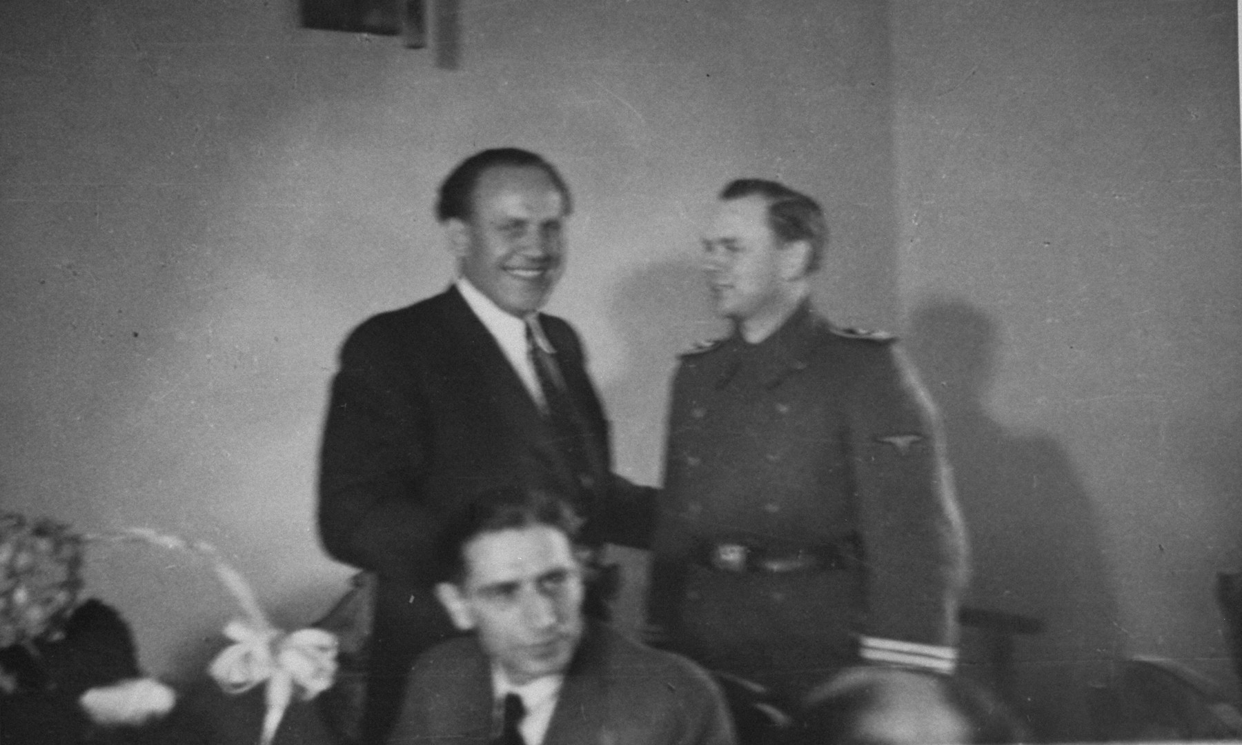 Oskar Schindler at a dinner party in Krakow with an SS officer.  

At parties like this, Schindler made contact with various SS and German officials, which often led to tips about impending deportations that enabled him to save his laborers.