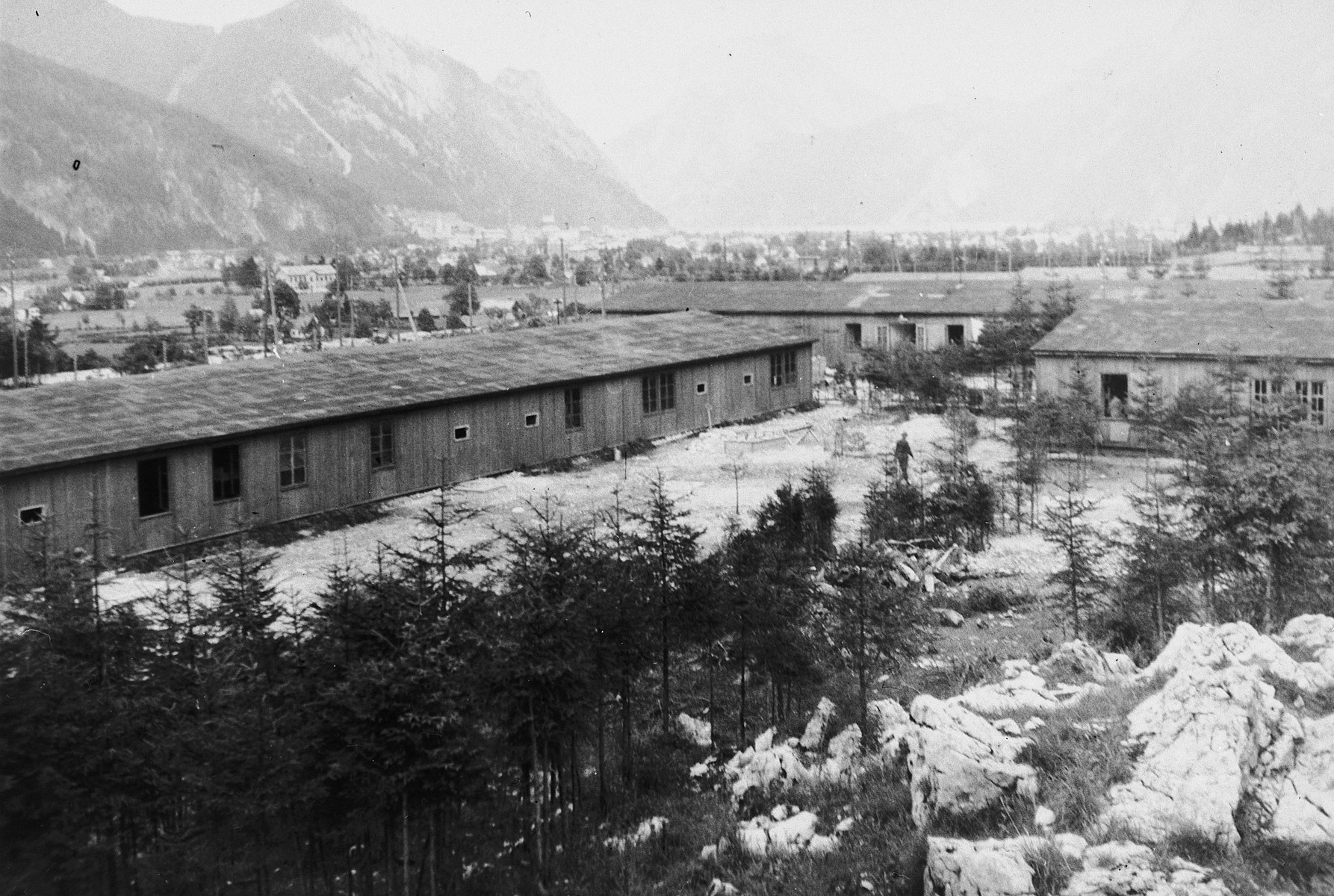 Exterior view of the barracks of the Ebensee subcamp of Mauthausen.

The original caption reads: "View of the barracks where the displaced persons lived.  They were allowed only body space and living three high."