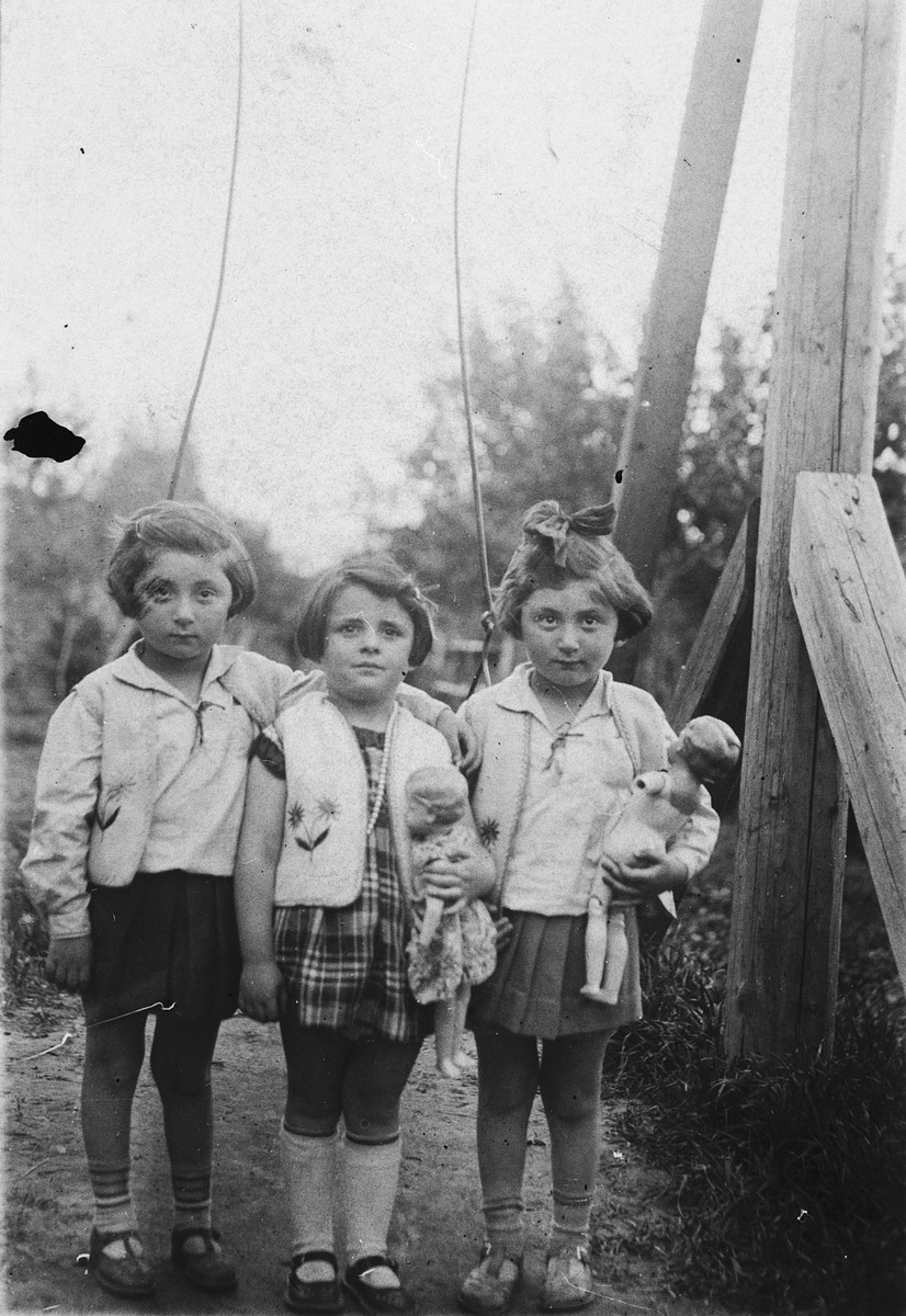 Sophie Kimelman poses with her twin cousins holding their dolls.