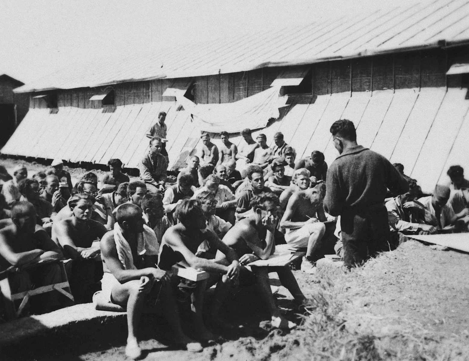 Prisoners listen to a talk in front of the barracks in the Gurs concentration camp in France.