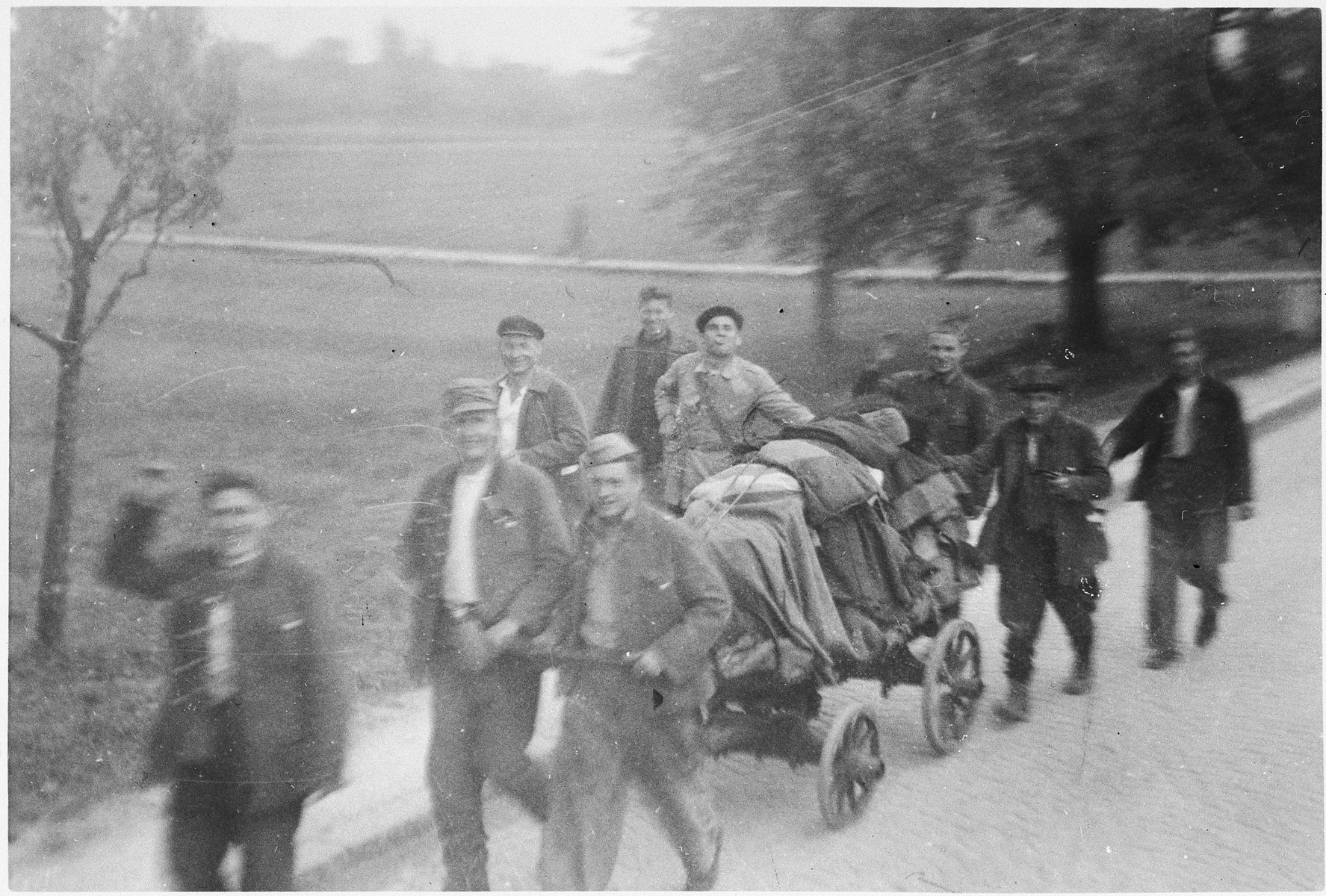 Jubilant survivors of the Ebensee sub-camp leave the camp with their few belongings.

The original caption reads: "Forced laborers going home."