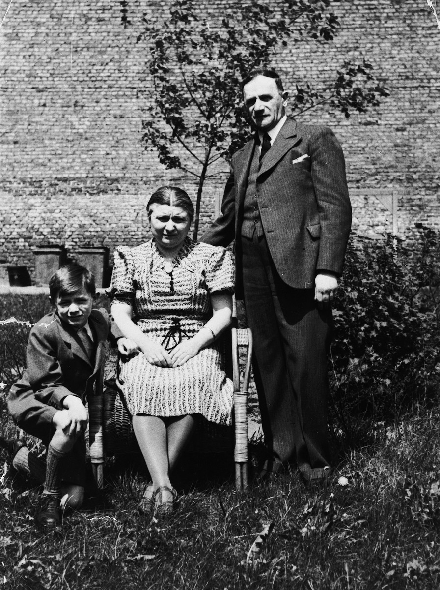 A young boy poses with his parents in a garden prior to his leaving Germany for France.

Pictured are Norbert, Bertha, and Salomon Bikales.