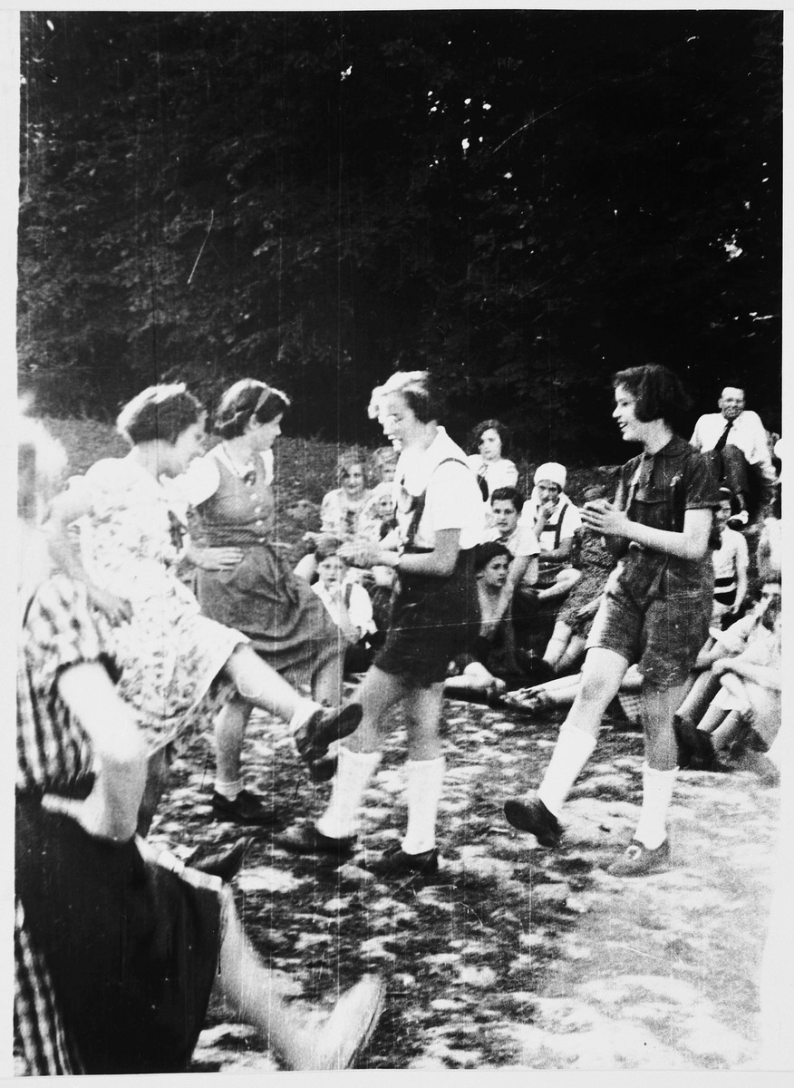 A group of Jewish refugee girls from the Chateau de la Guette OSE [Oeuvre de Secours aux Enfants] children's home dance outside.

Among those pictured is Erika (Fée) Beyth (center) and Renate Tauber (right).