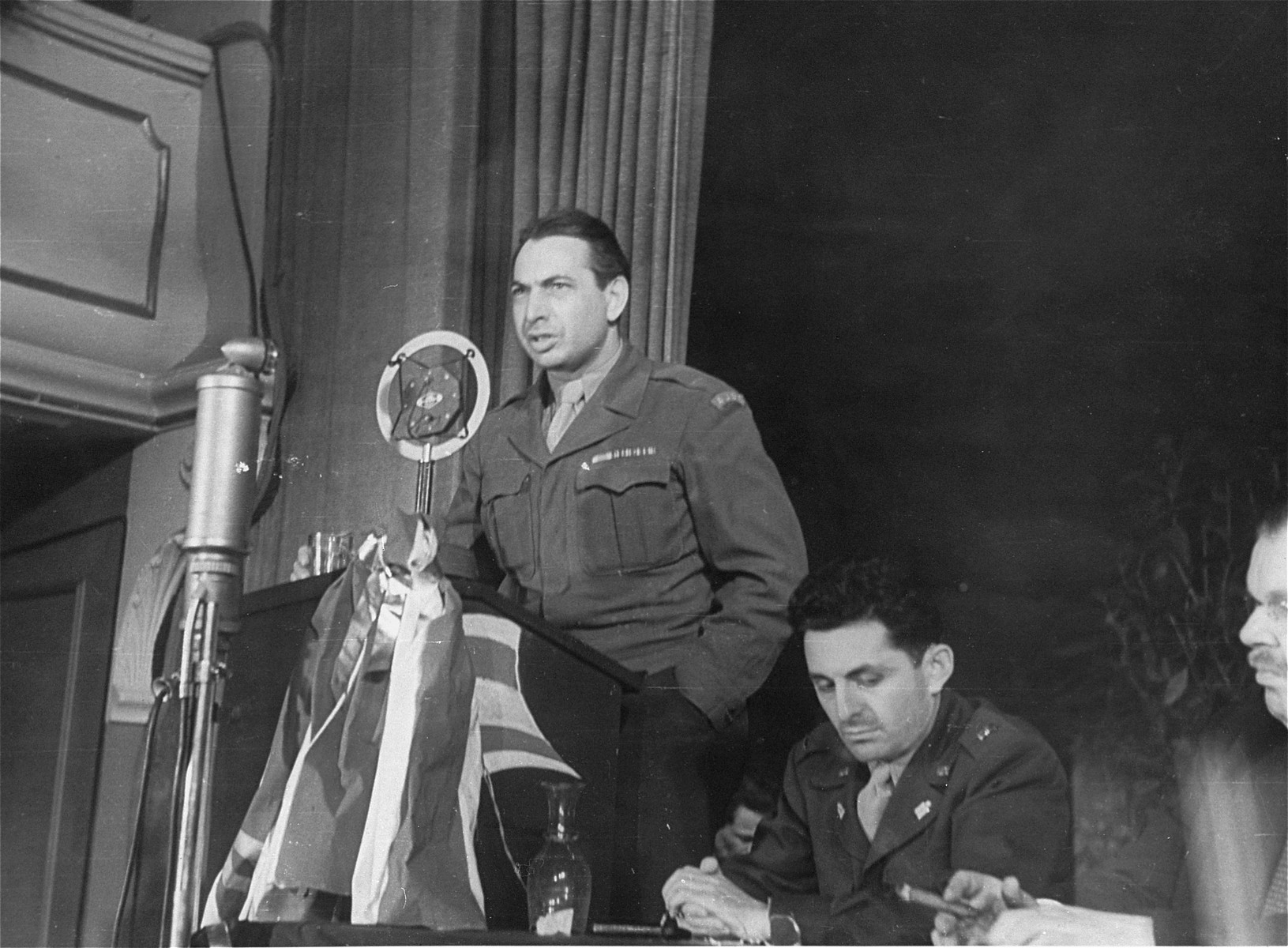 Leo Schwarz, JDC director for Germany, addresses a conference of the Central Committee of Liberated Jews in the U.S. Zone of Germany.  

Seated next to the speaker is U.S. army chaplain Abraham Klausner.