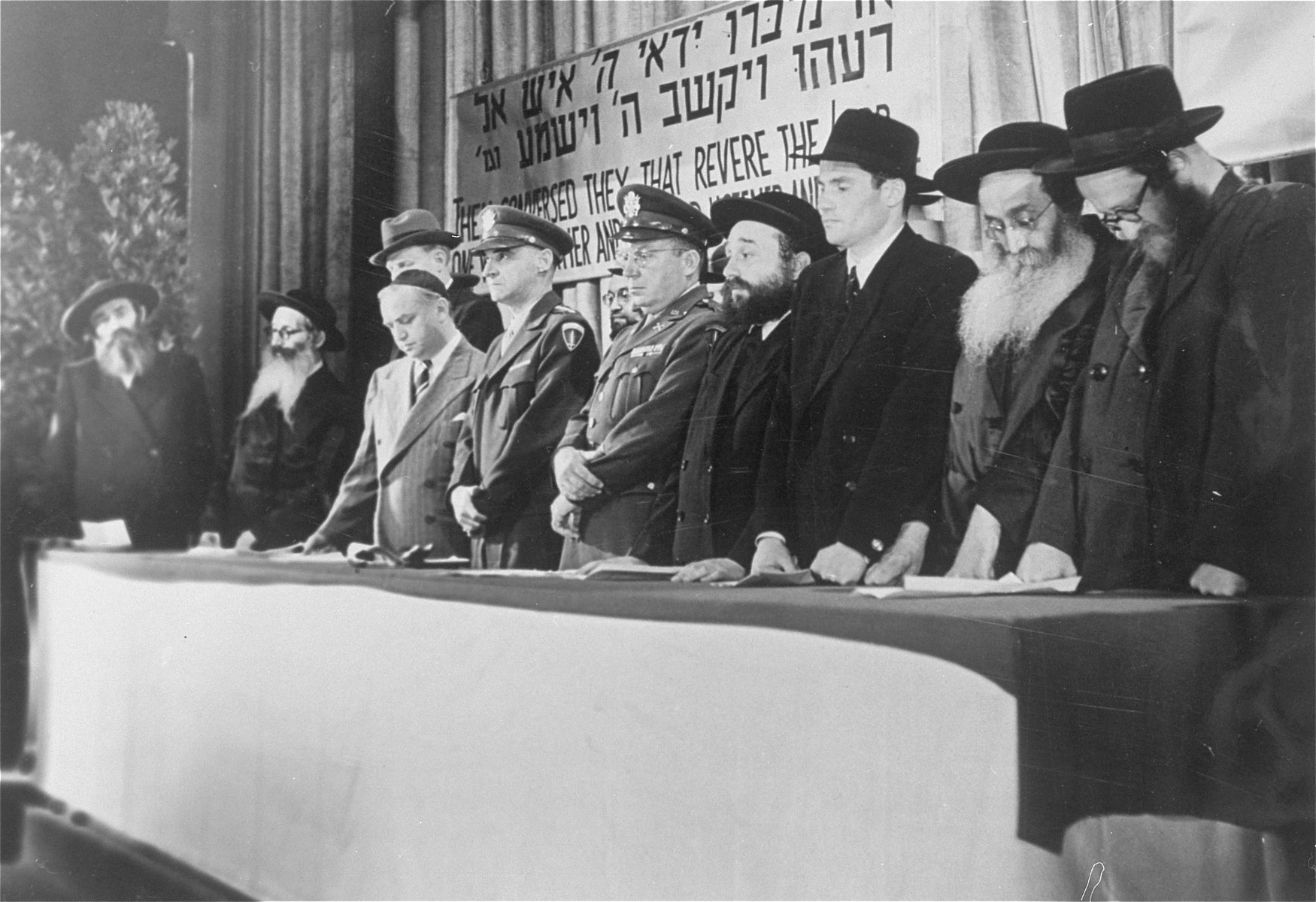 American military officers stand at the dais with a group of orthodox rabbis at a DP conference in Frankfurt.