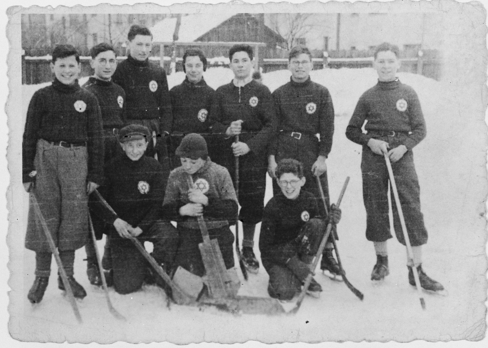 Members of a Jewish ice hockey team wearing stars of David on their shirts pose in the snow.