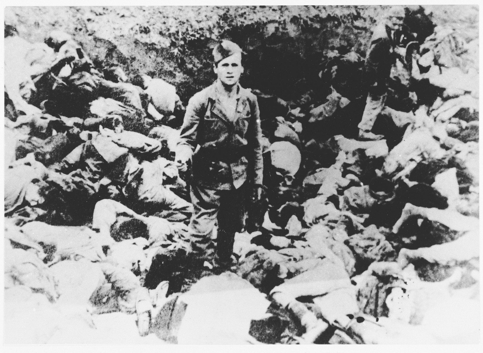 An Ustasa guard stands among the bodies of prisoners murdered in the Jasenovac concentration camp.