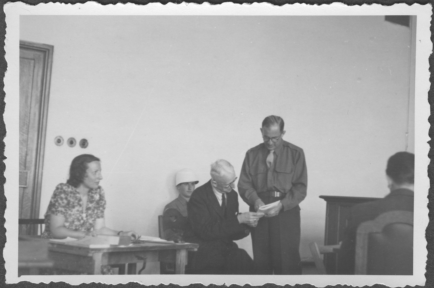 American assistant prosecutor Robert M.W. Kempner shows a document to German Field Marshall Erich von Manstein at the IMT Nuremberg commission hearings investigating indicted Nazi organizations.

Also pictured is the interpreter, Mrs. Lowenstein.