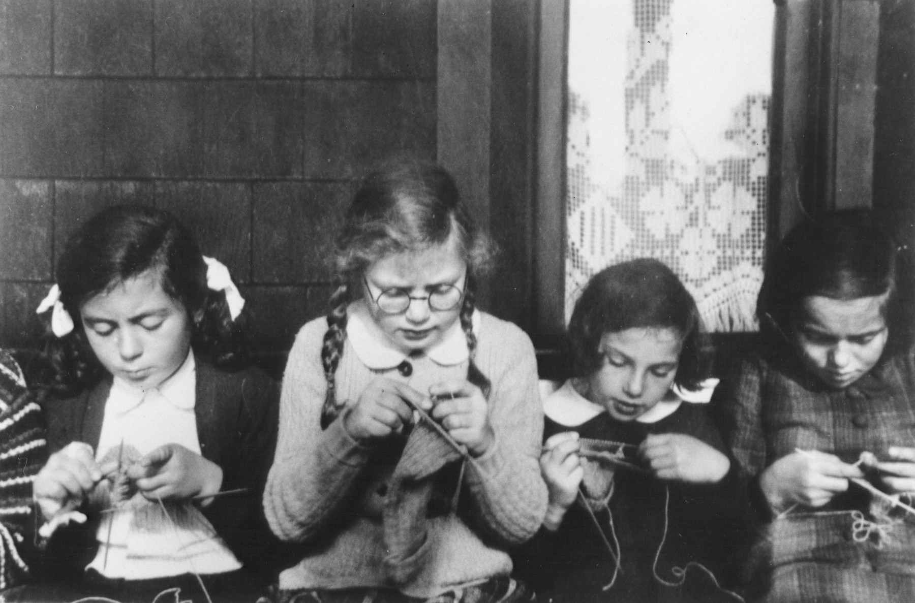 Jewish refugee children knit for the war effort in the Larino home in Balwyn, outside of Melbourne.

Pictured left to right are Margot Goldstein, Jo Lehmann, Ellen Rothschild and Ellen Lewinski.  The home was sponsored by the Jewish Welfare Society.