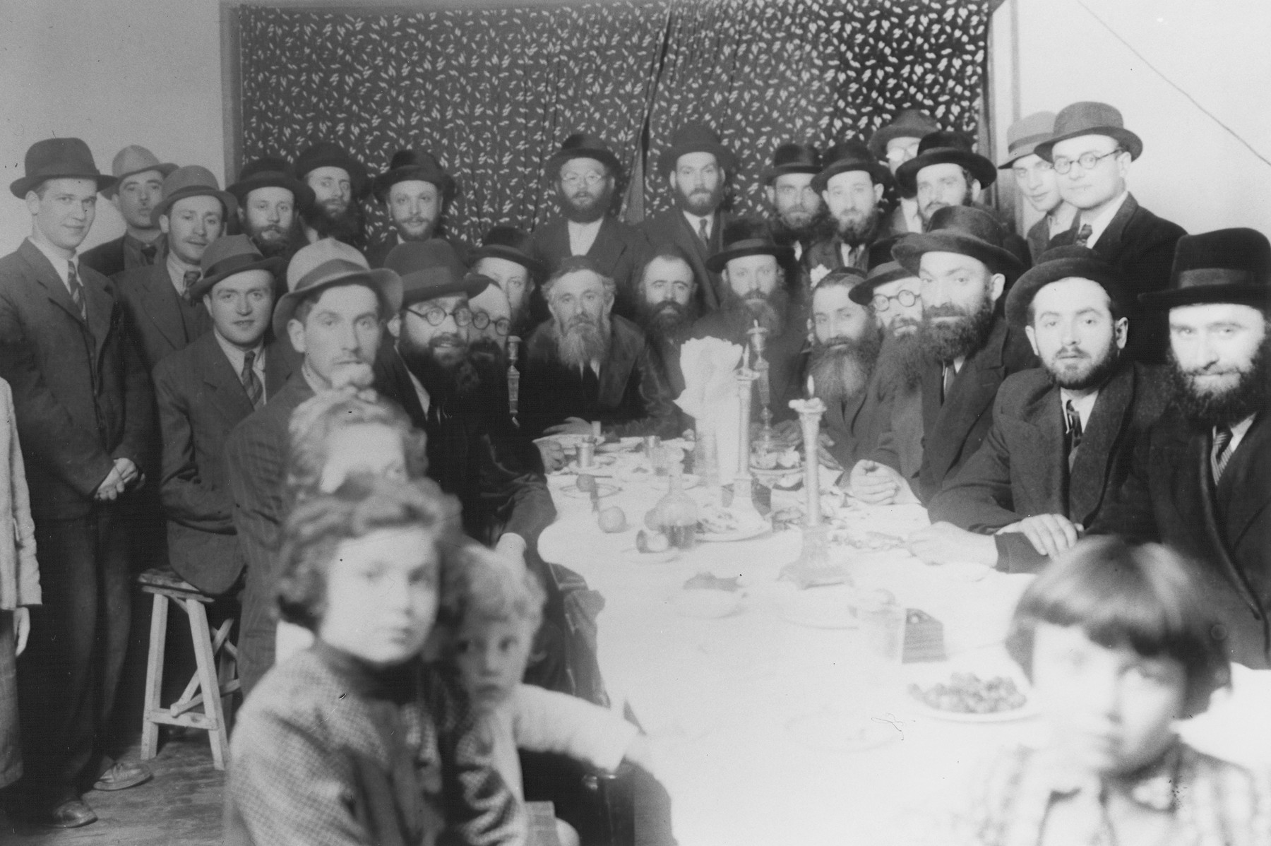 Group portrait of religious Jewish refugees from Poland at a dinner in Shanghai.

Among those pictured are Rabbi Walkin and his daughters.