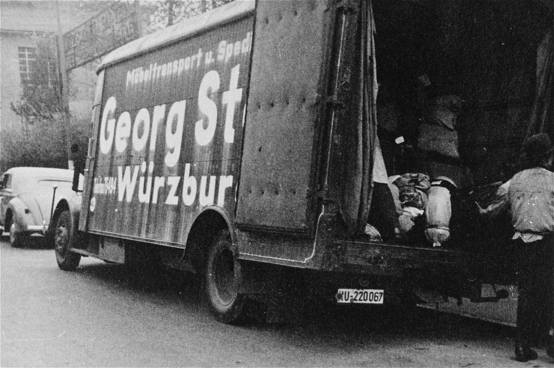 The bundles and suitcases of the Jewish deportees are loaded onto a moving van.