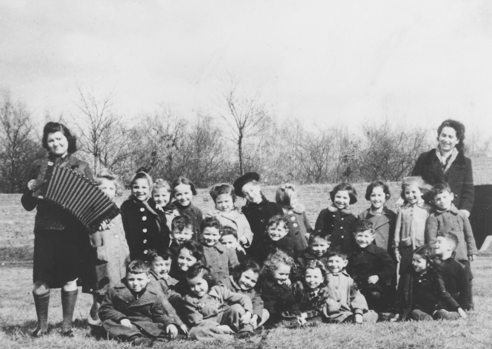 Preschoolers in the Mariendorf displaced persons camp enjoy the music of an accordian.

Those pictured include Maya Rosenfeld (later Freed Brown).