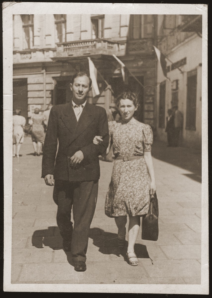 Mania Gryniewicz walks in the street with her husband, Gutman.