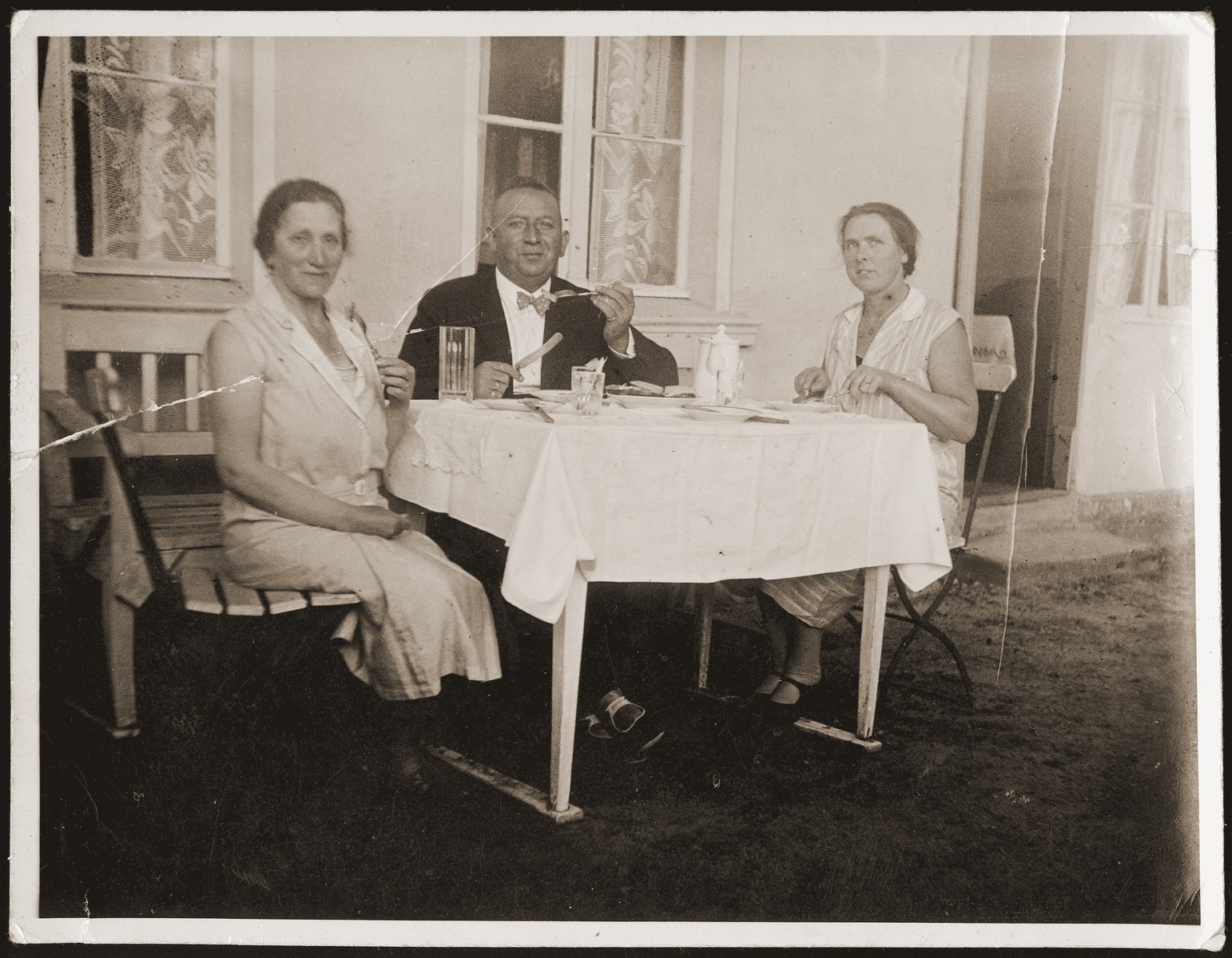 Siegfried and Betti Jacobsberg eat a meal in their garden with their German maid, Minna.