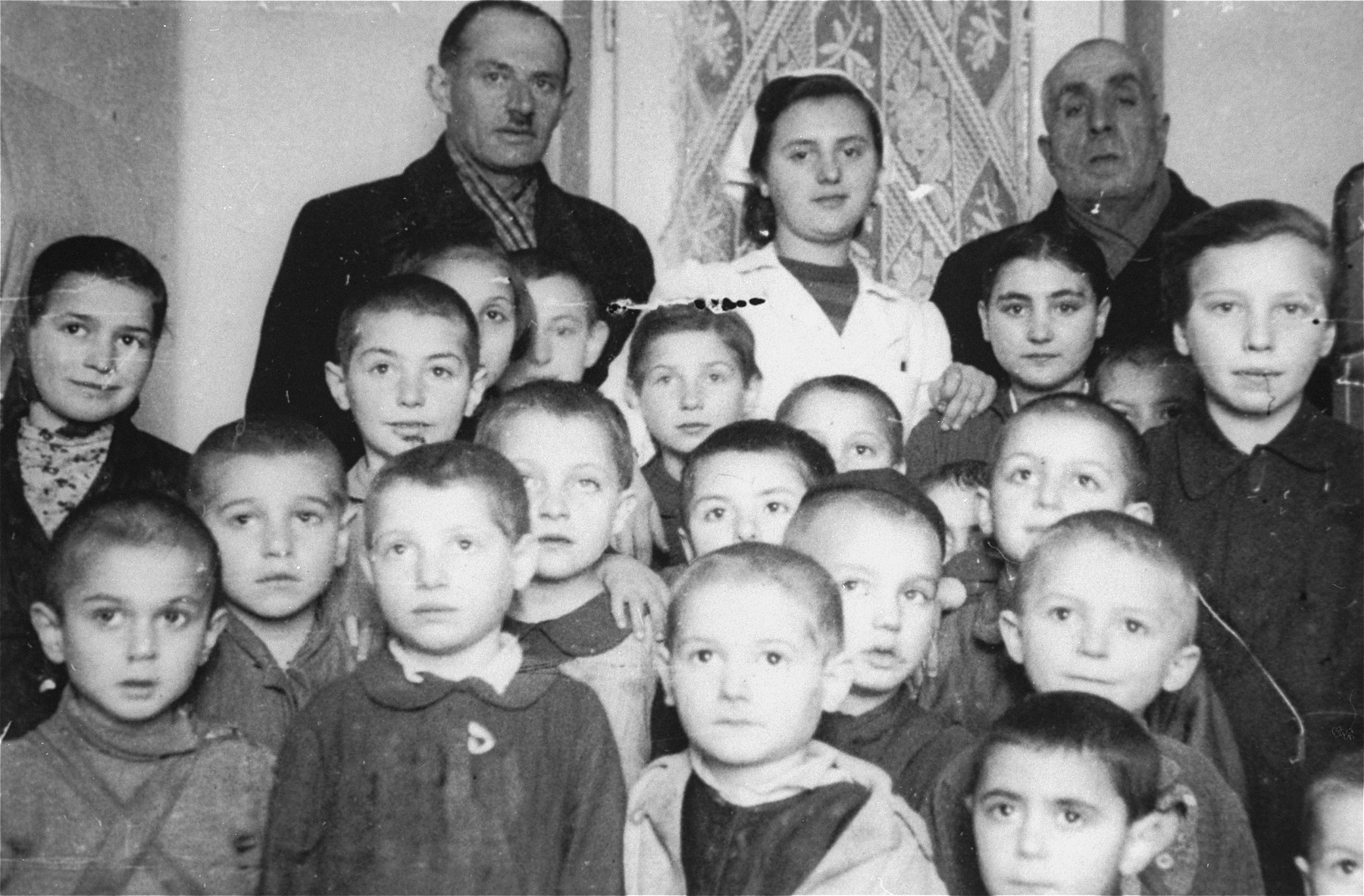 Group portrait of the children and staff of a daycare center in the Kielce ghetto that was administered by the Judenrat (Jewish Council).

This photo was one the images included in an official album prepared by the Judenrat of the Kielce ghetto in 1942.
