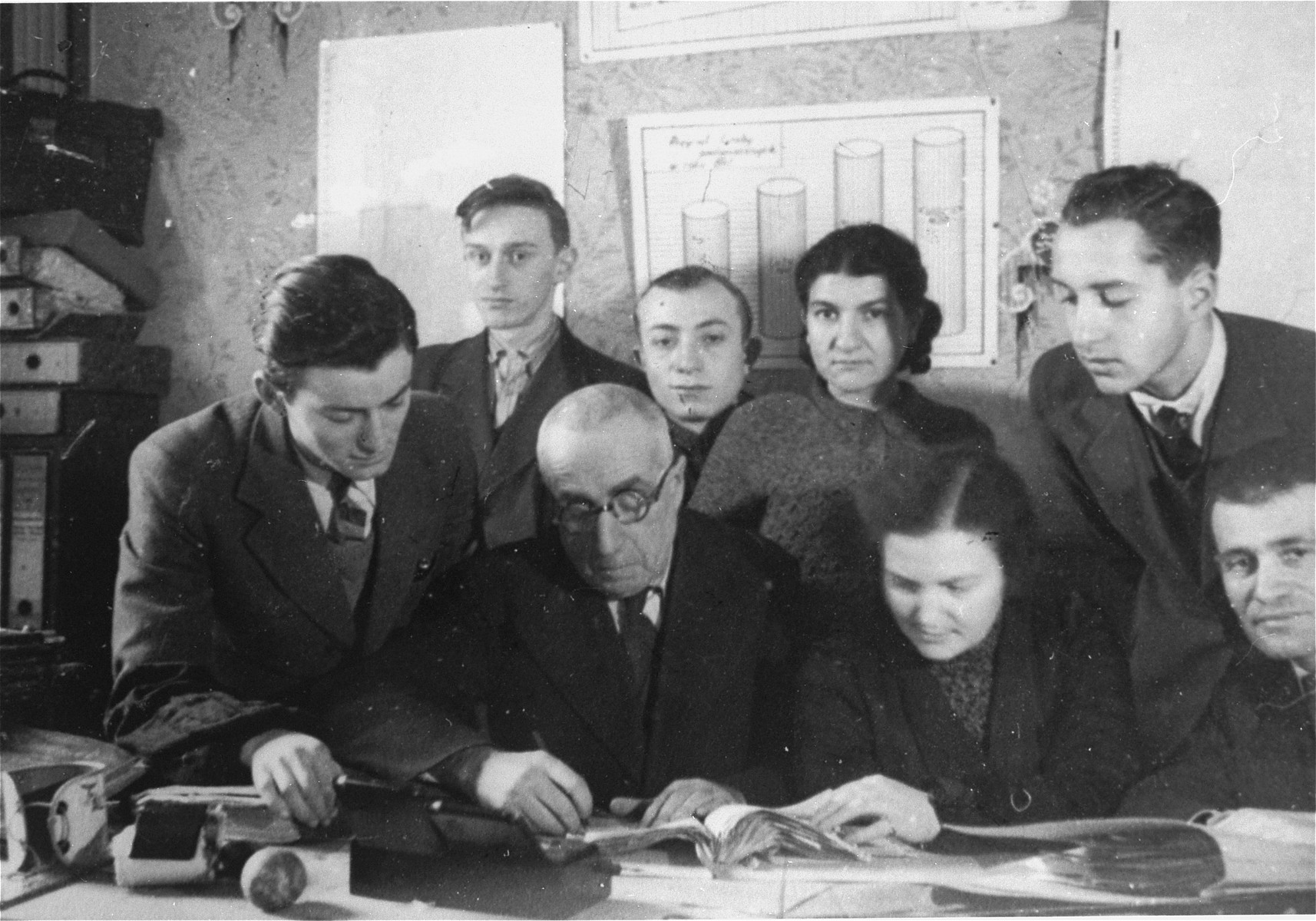 Group portrait of members of the administrative staff of the Kielce ghetto Judenrat (Jewish Council) in their office.

This photo was one the images included in an official album prepared by the Judenrat of the Kielce ghetto in 1942.