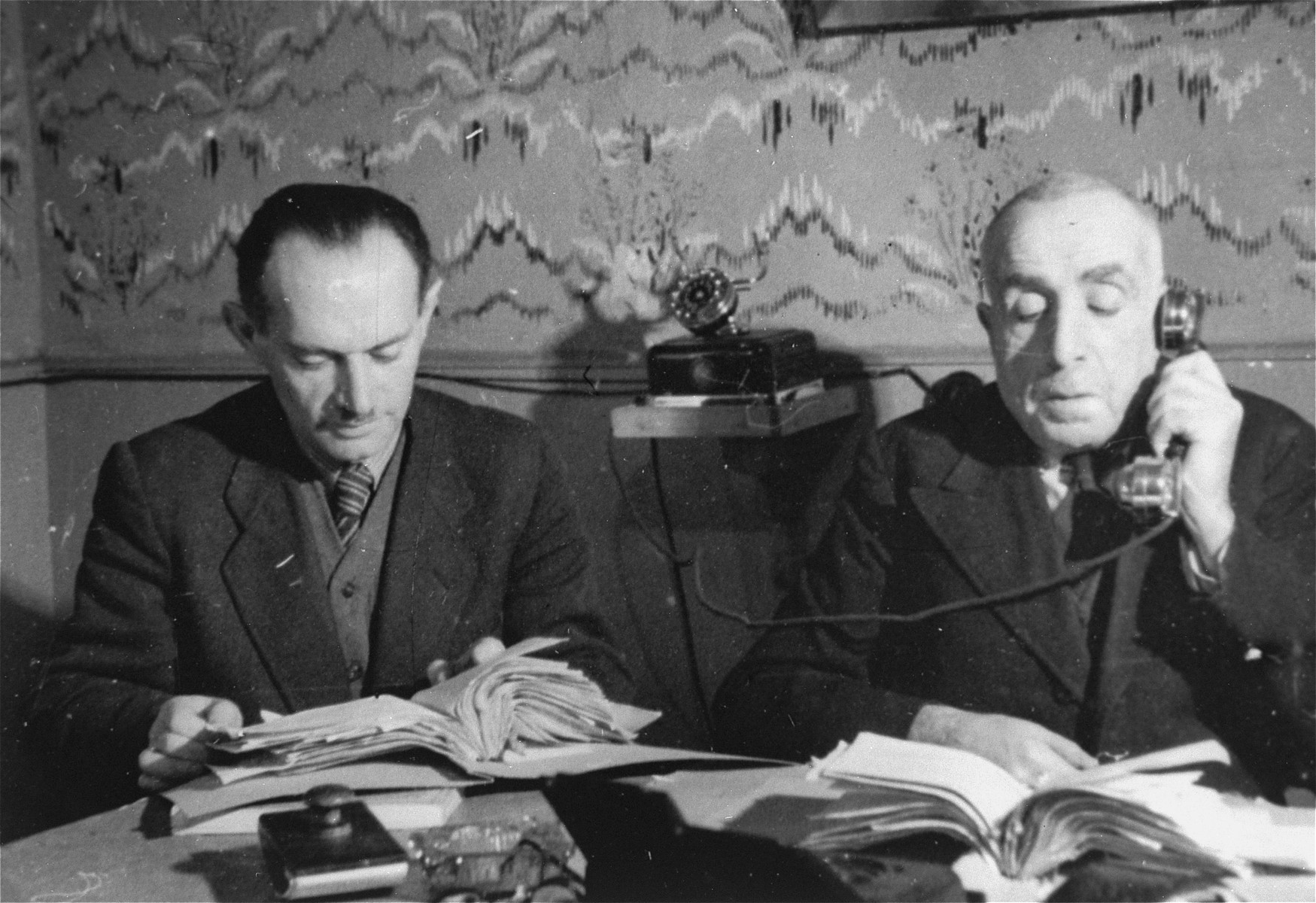 Two members of the ghetto administration at work in the office of the Judenrat in the Kielce ghetto.

This photo was one the images included in an official album prepared by the Judenrat of the Kielce ghetto in 1942.