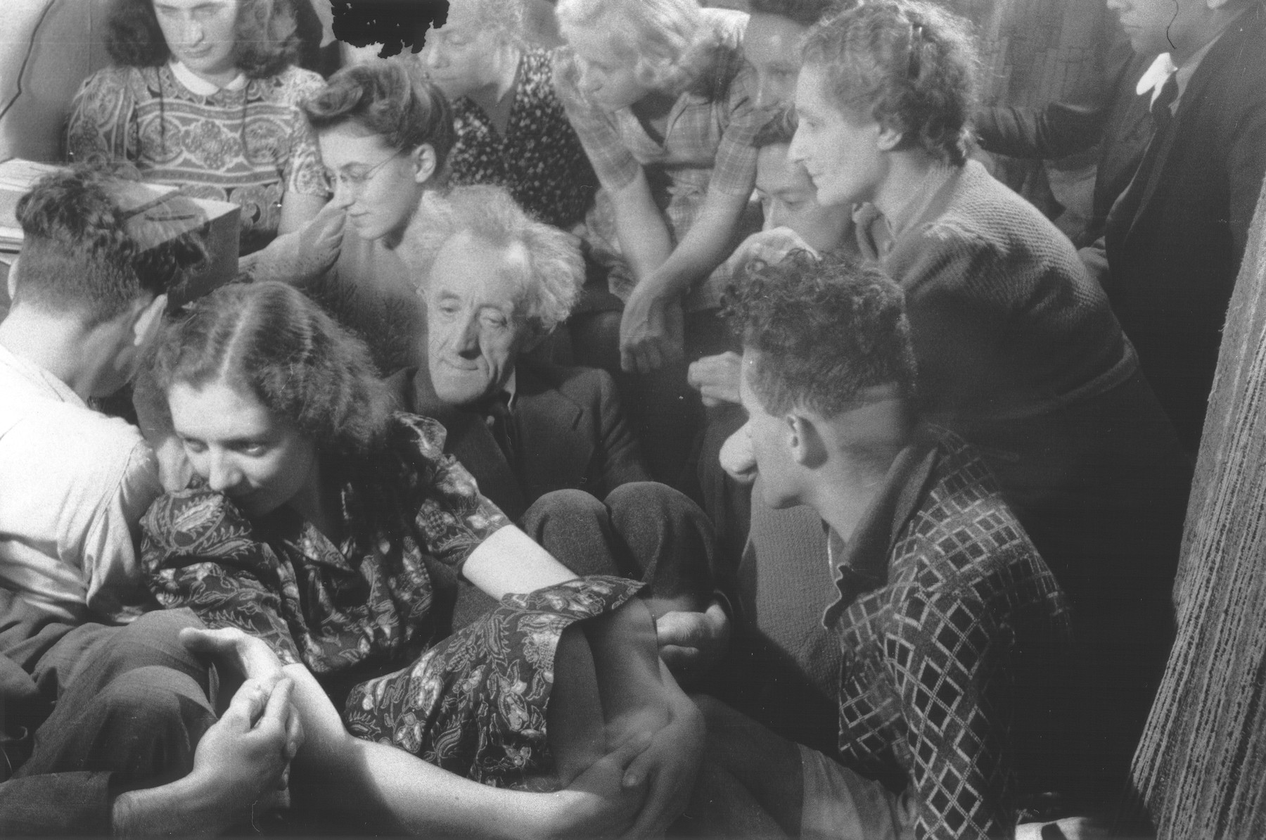 A group of Dutch resistance members and hidden Jews are crowded into a room [possibly to listen to a clandestine radio].

Those pictured include Hans Pos, Marie Scheres, Bep Klant, Phiep Vahrmayer, Rosette Aussen-Muscoviter, Oei Tjensit, Benno Aussen and Lizzy Pos.