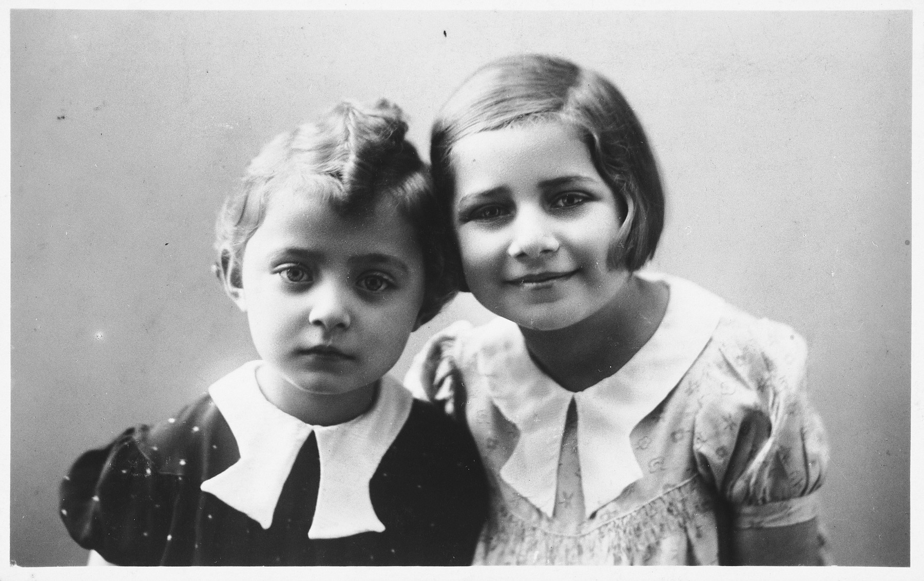 Studio portrait of two young Jewish sisters in Holice, Czechoslovakia.

Pictured are Gabriella and Katerina Frei.