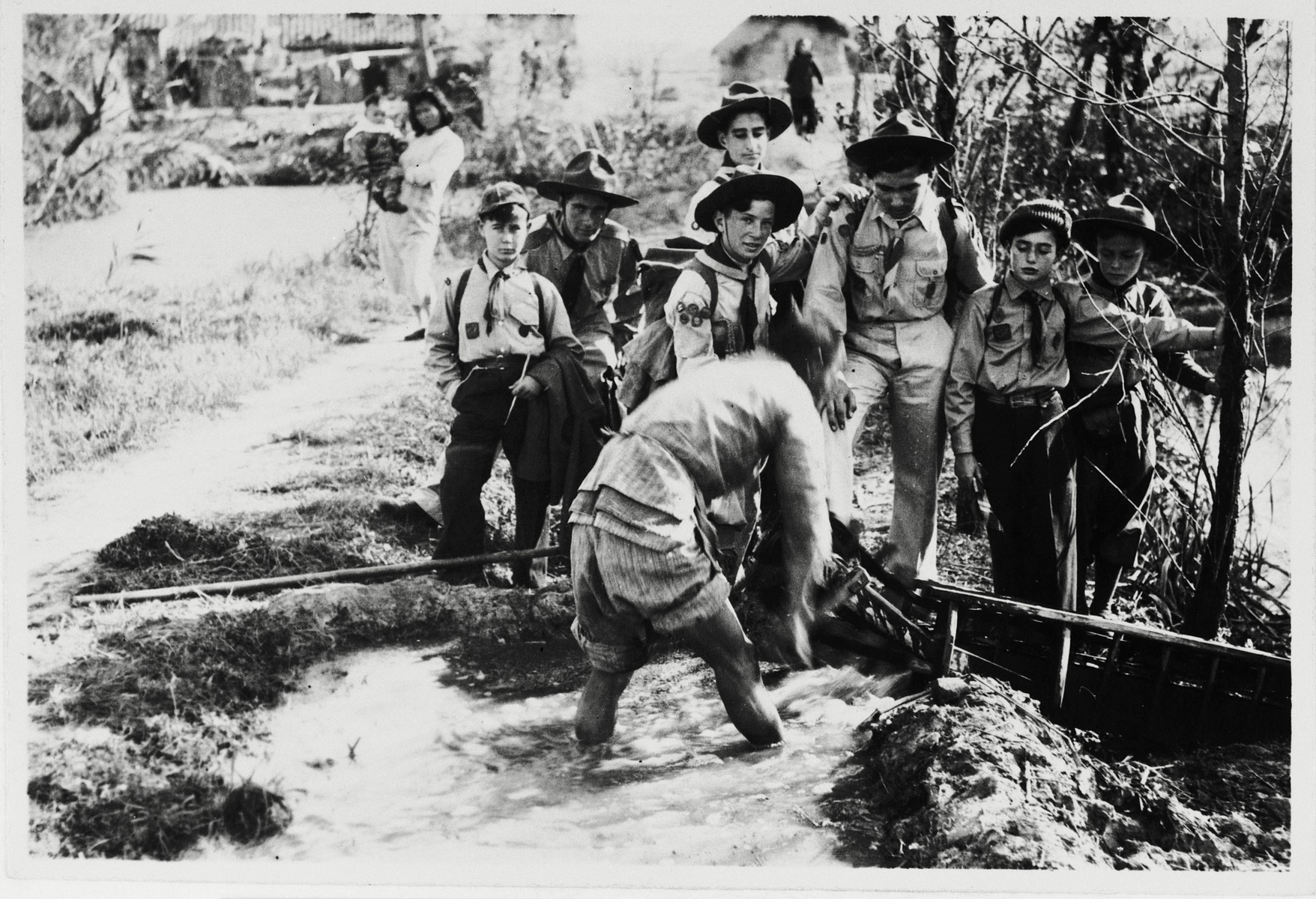 Jewish boy scouts in China watch the watering of ricefields.