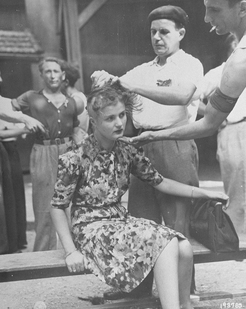 Members of the French resistance shear the hair of a young woman who consorted with the Germans during the occupation.