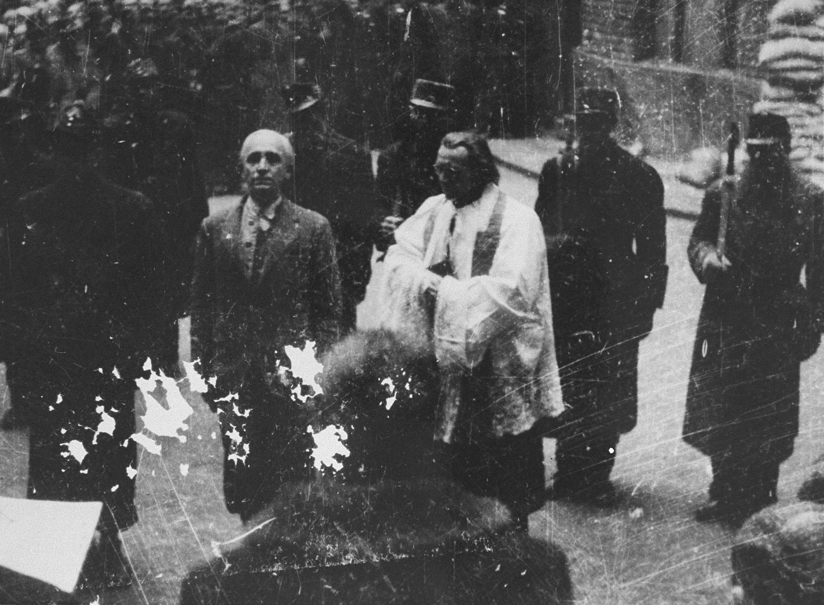 A Hungarian official reads the death sentence of former Prime Minister Dr.  Laszlo V.  Bardossy prior to his execution in the courtyard of the Academy of Music in Budapest.

The trial of Laszlo V. Bardossy was the first postwar trial of a suspected Hungarian war criminal to be carried out by the People's Tribunal in the Academy of Music in Budapest.  Bardossy was charged as former prime minister with illegally involving Hungary in war against the Soviet Union and with responsibility for allowing the massacre of Jews at Kamenets-Podolsk in July 1941.  Bardossy's trial was convened on October 29, 1945 and he was convicted on November 3, 1945.  His execution was carried out on January 10, 1946.