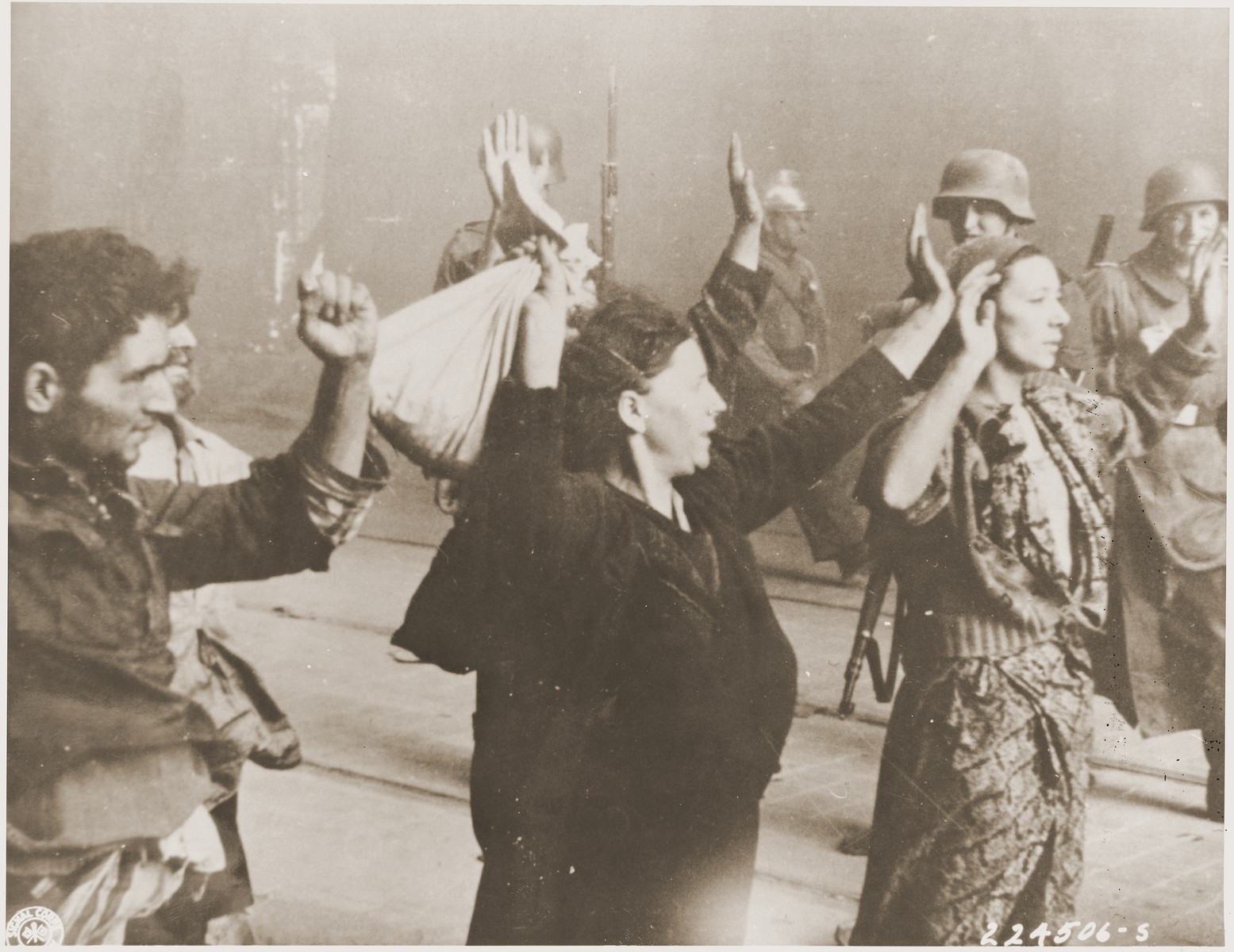 Members of the Jewish resistance are captured by SS troops on Nowolipie Street during the suppression of the Warsaw ghetto uprising.  The original German caption reads: "These bandits offered armed resistance."

Original caption from donated photograph reads:  "The following pictures are copies of the book containing the report of the German commander who was responsible for cleaning out that ghetto in Warsaw, Poland.  This report, in the form of a leather bound book, was presented as evidence by the U.S. prosecution, Maj. Frank Walsh, at the international tribunal trials at Nurnberg, Germany."