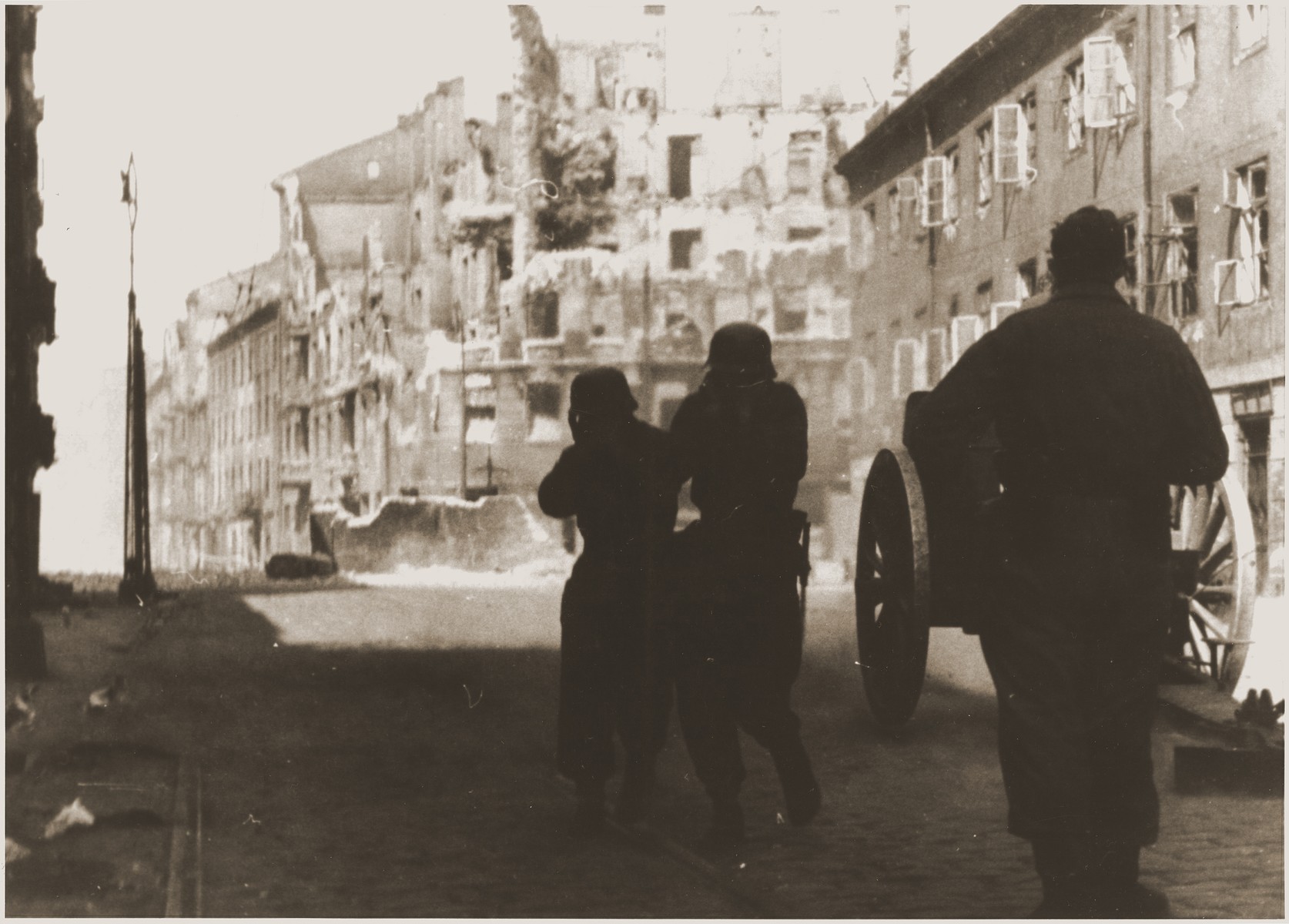 A German gun crew shells a housing block during the suppression of the Warsaw ghetto uprising.  

The original caption (translated from German) reads: "Destruction of a housing block."