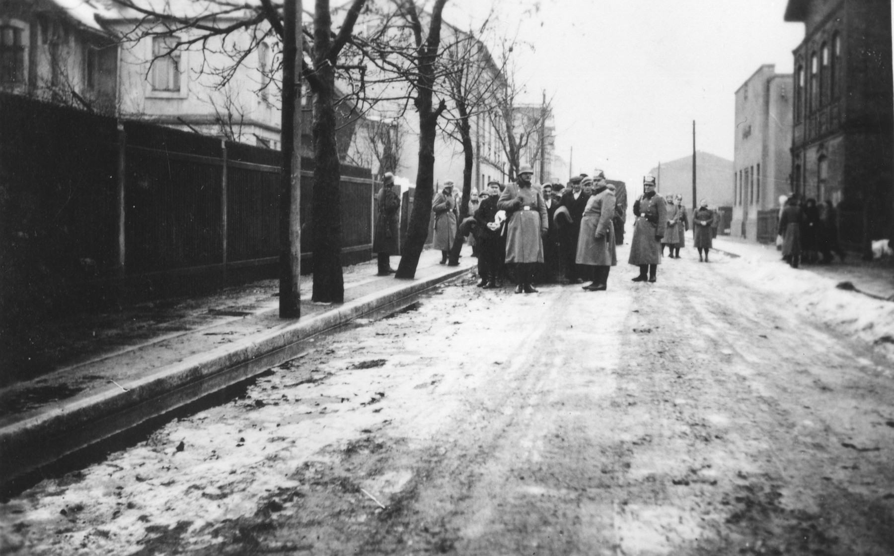 Jews are rounded up and assembled in columns on a street in the Zawiercie ghetto.