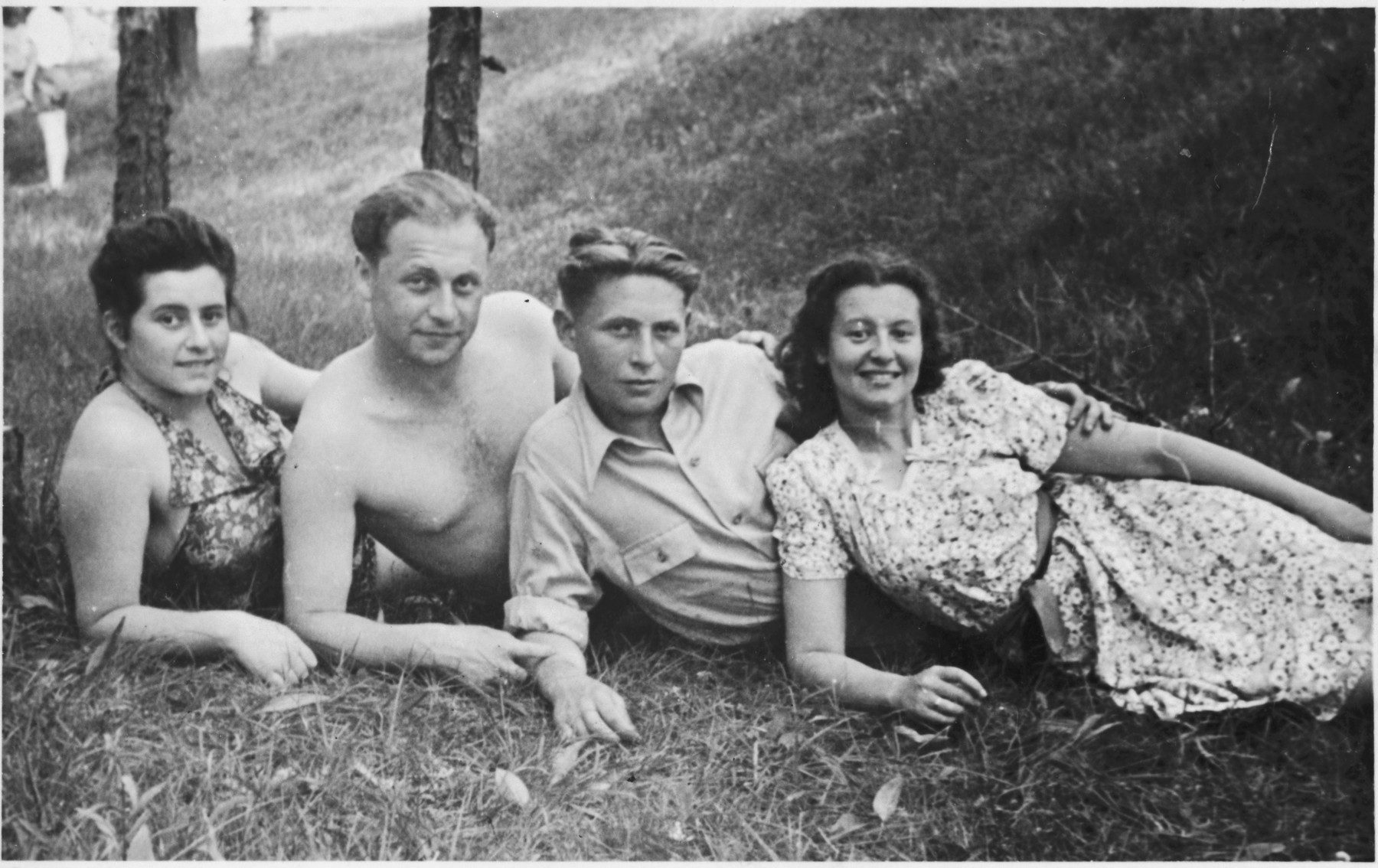 Four Jewish displaced persons lounge at the bottom of a grassy field.

Pictured are Dr. Genishevitz (second from left), his wife Ellis (far right), and two of their friends. 

Dr. Genishevitz, a partisan, studied dentistry for four years in Germany before becoming accredited and immigrating to the United States. He said he wanted to avenge the German who had killed his father, and he managed to do so.