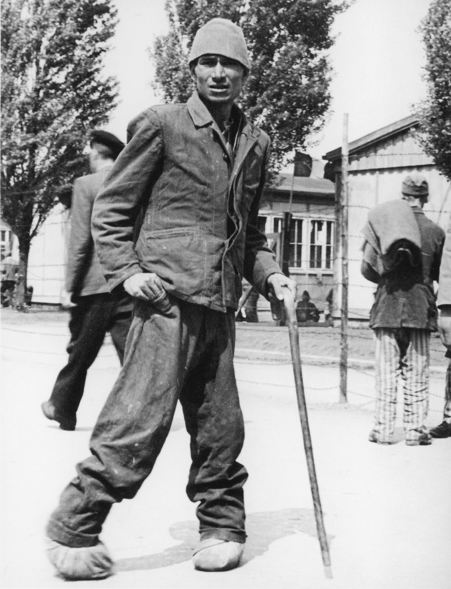 Close-up portrait of a survivor of the Dachau concentration camp with a cane.