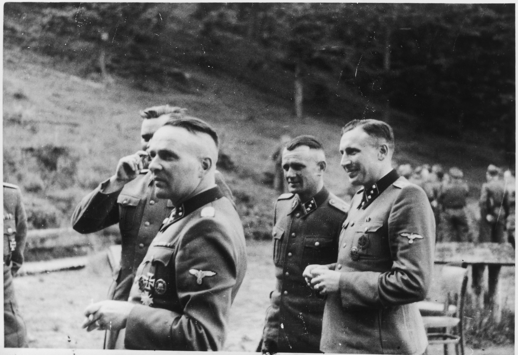 SS officers socialize on the grounds of the SS retreat Solahuette outside of Auschwitz. 

From left to right they are: Rudolf Hoess, Josef Kramer (partially obscured behind him), Anton Thumann and Karl Hoecker.

[Based on the officers visiting Solahutte, we surmise that the photographs were taken to honor Rudolf Hoess who completed his tenure as garrison senior on July 29.]
